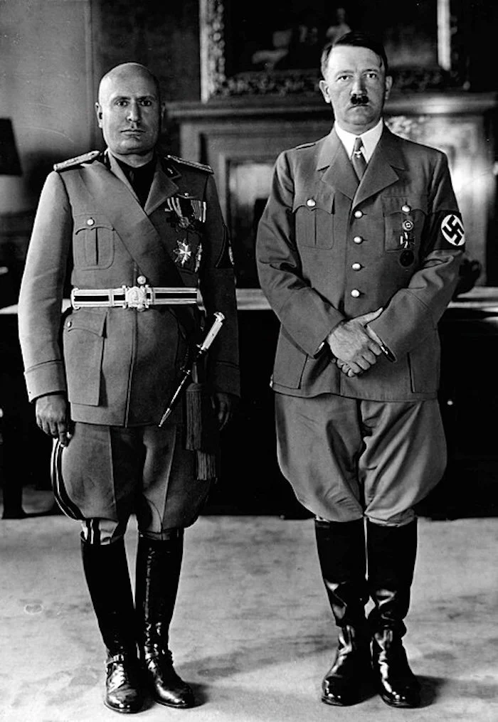 Black and white photo of two stern men in military uniforms