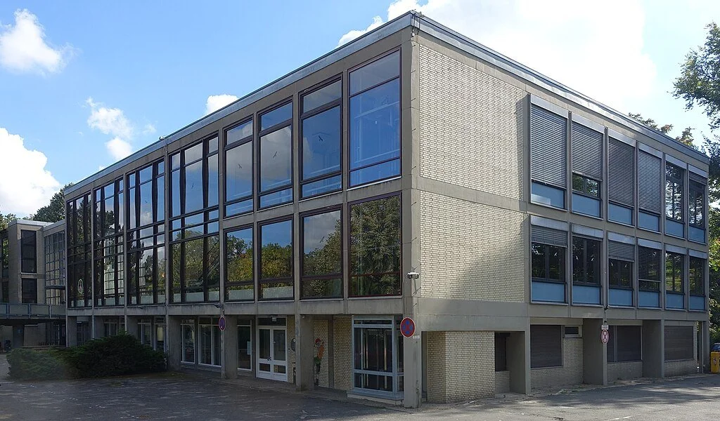 Three-story flat-roofed building with mostly glass walls