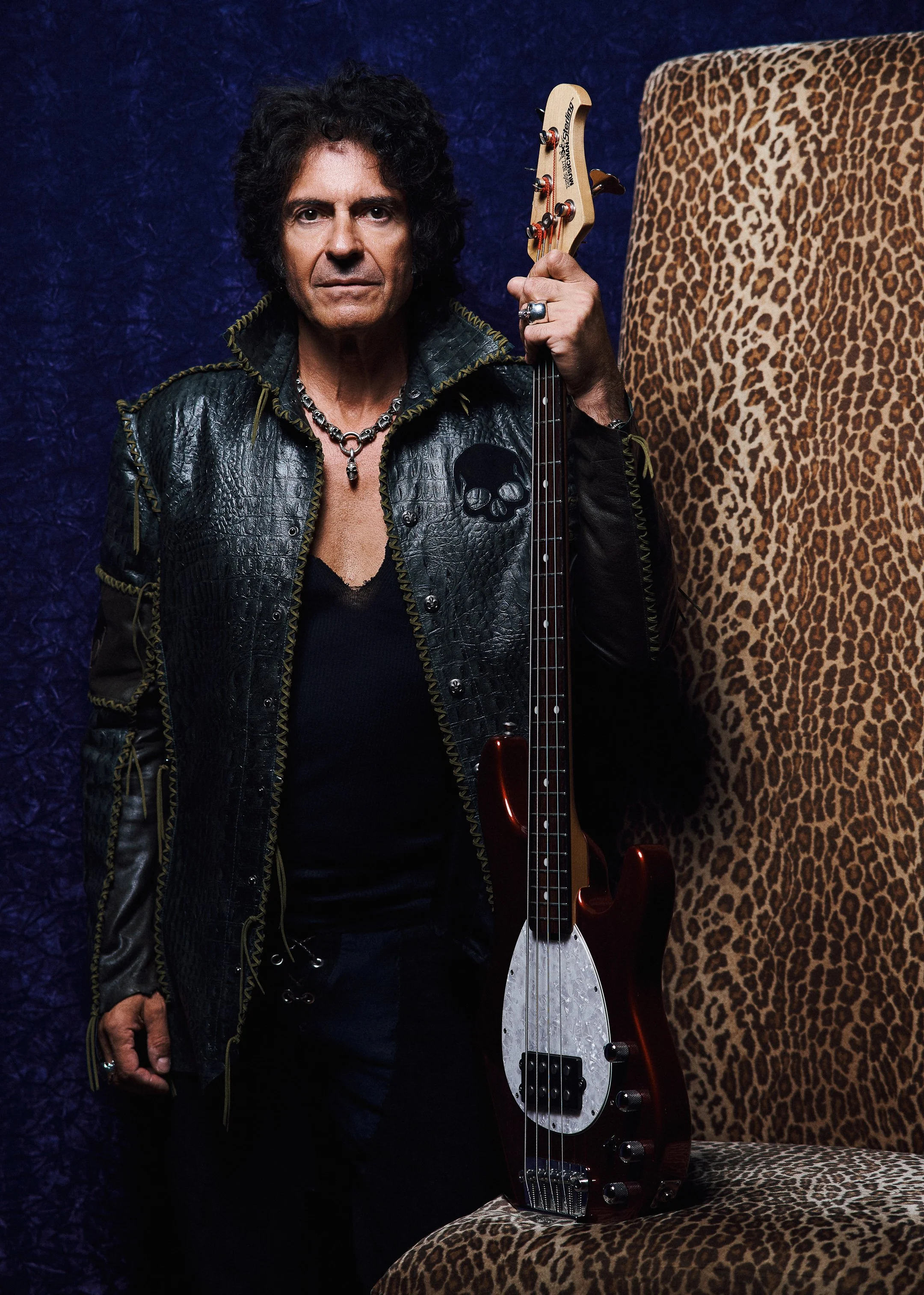 Professional portrait of Phil Soussan, world-renowned rock bassist, photographed standing with his bass guitar in a dramatic studio portrait.