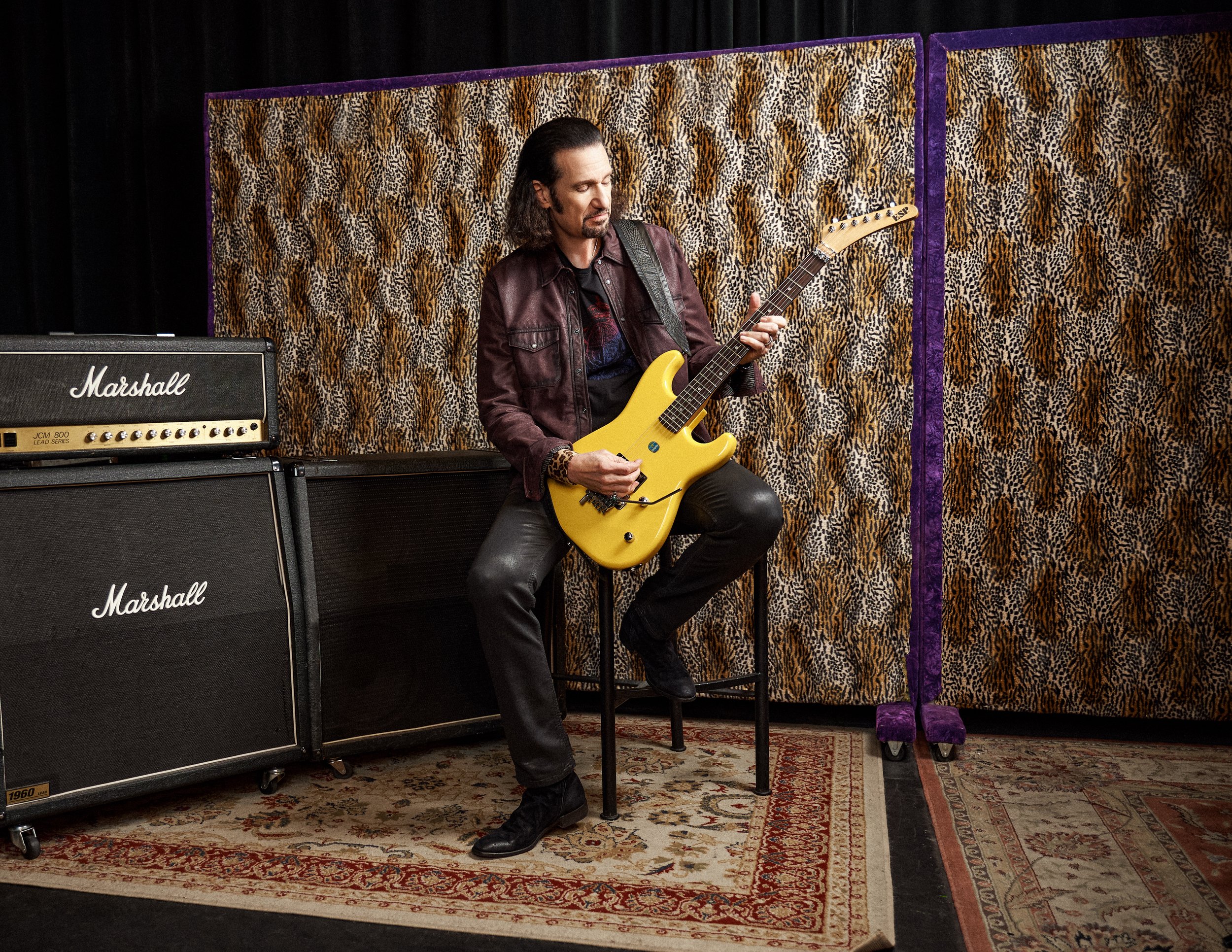 Bruce Kulick photographed with his signature Kulick boutique guitar, representing his continued influence in modern guitar design