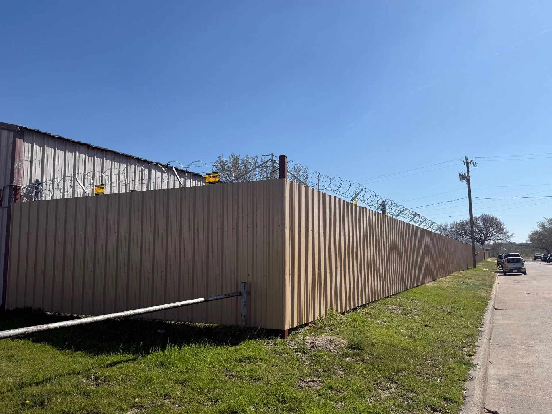 Commercial R-Panel Fence With razor and barbed wire.jpg