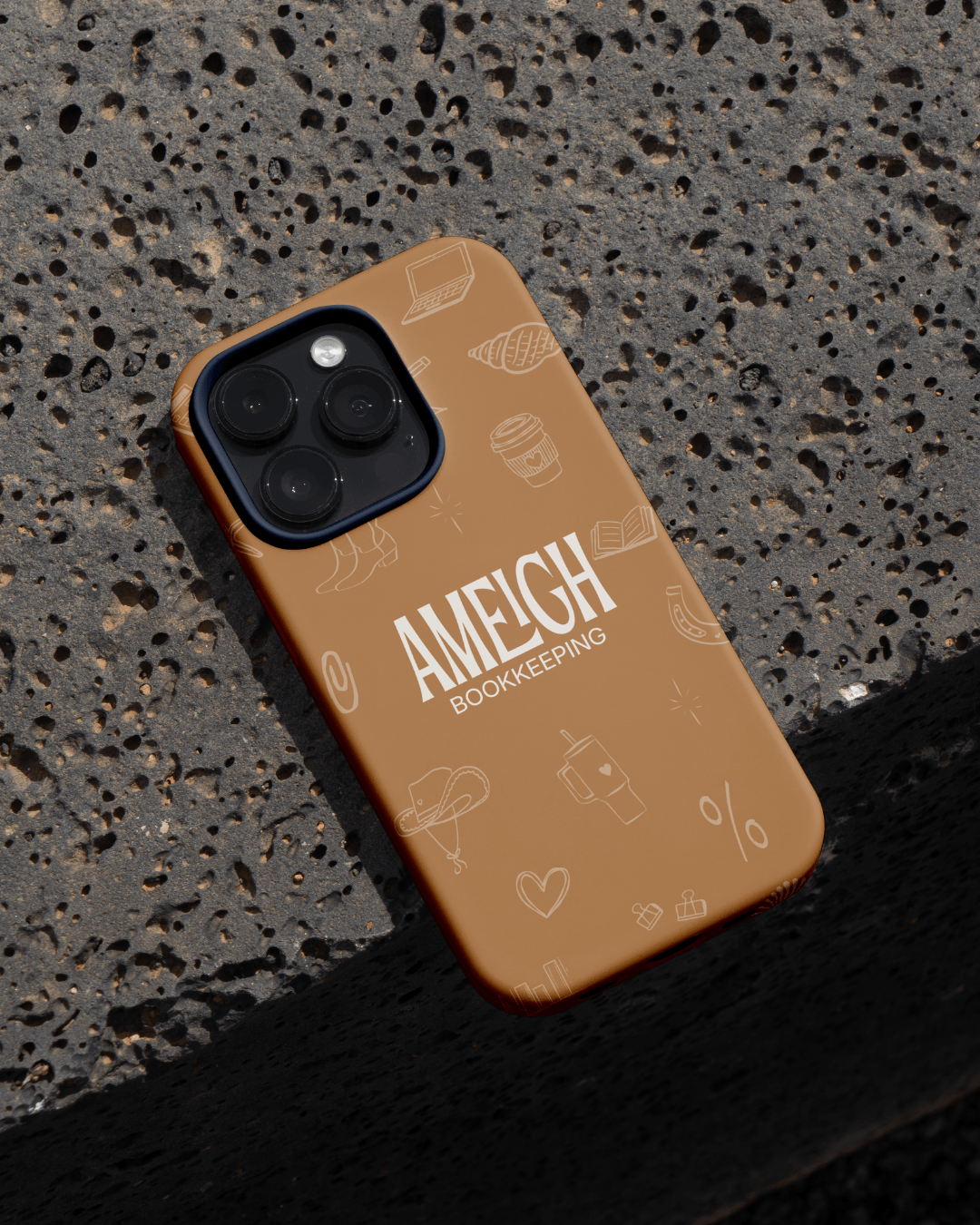Ameigh Bookkeeping branded phone case featuring logo and custom illustrated icons in a warm, modern colour palette