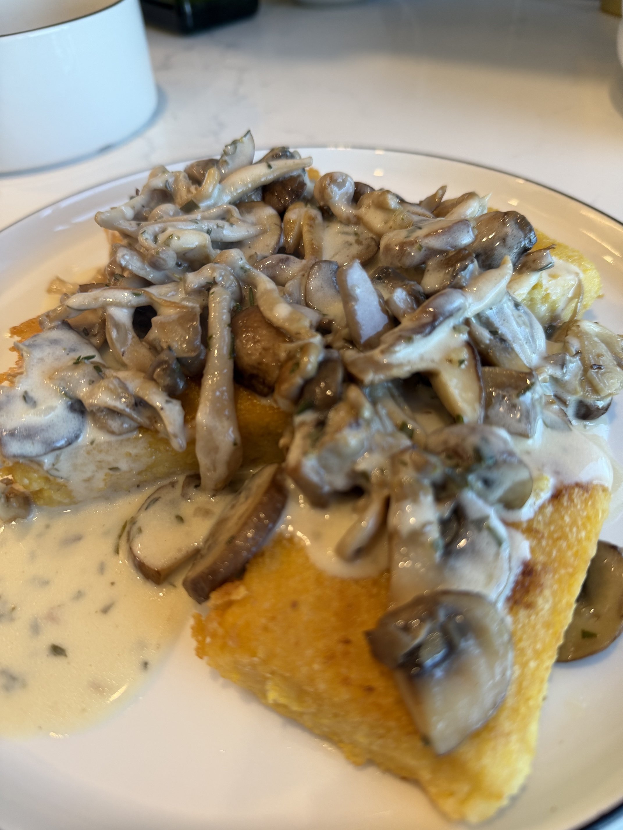crispy polenta topped with creamy mushroom sauce plated by private chef Anthony Chiero of The Simmering Chef for an in-home dinner party in East Greenwich, RI.