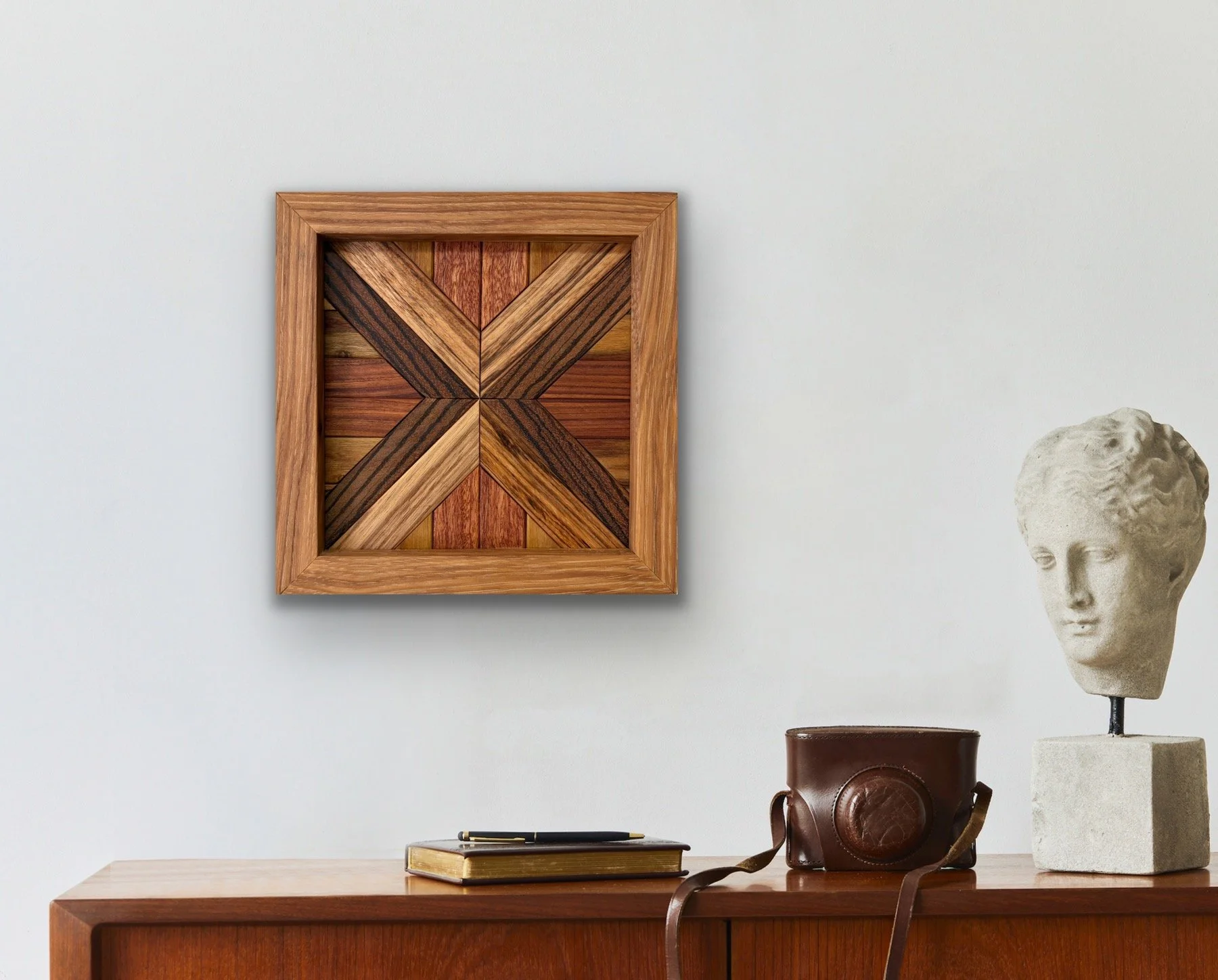 Handcrafted framed wooden mosaic made from various exotic woods hanging on a wall.