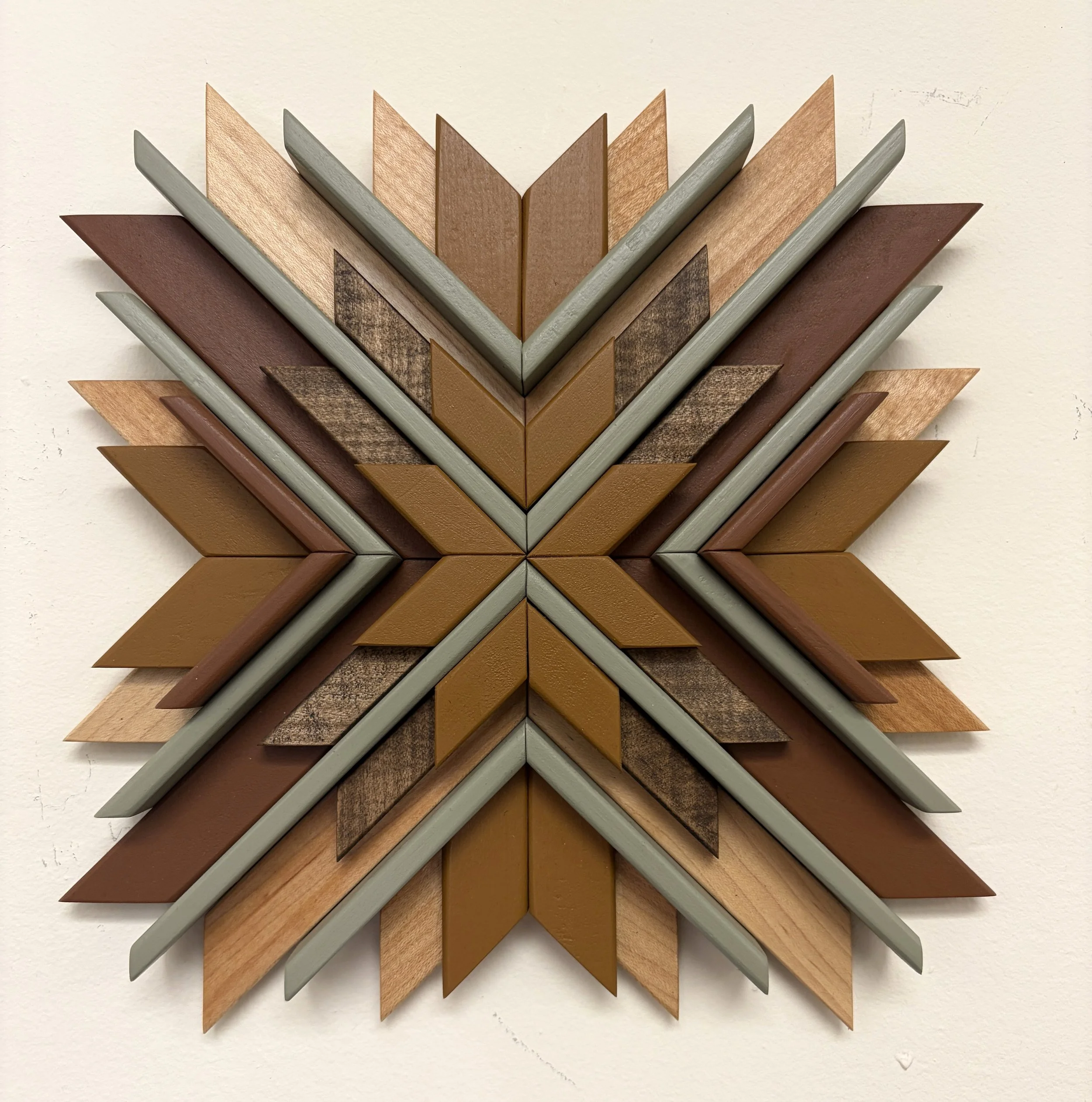 Wooden sunburst style mosaic in green, yellow, and orange paint with natural and espresso stains.