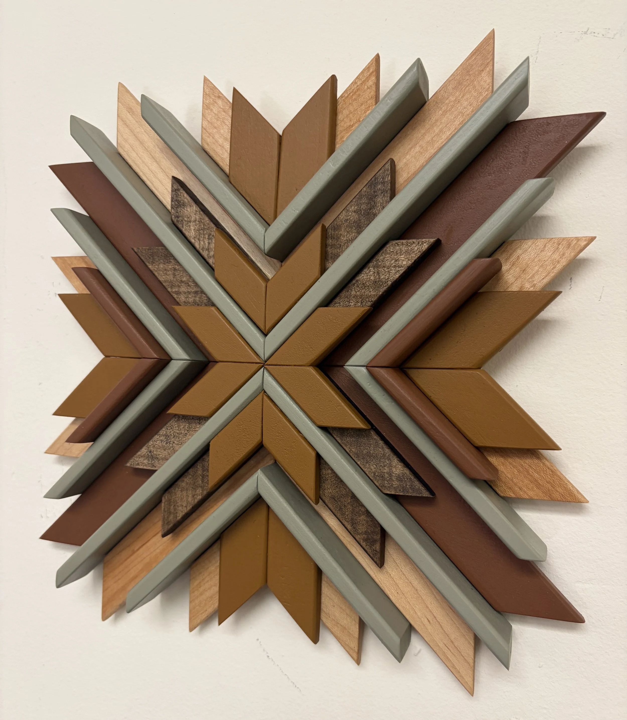 Side view of a wooden sunburst style mosaic in green, yellow, and orange paint with natural and espresso stains.