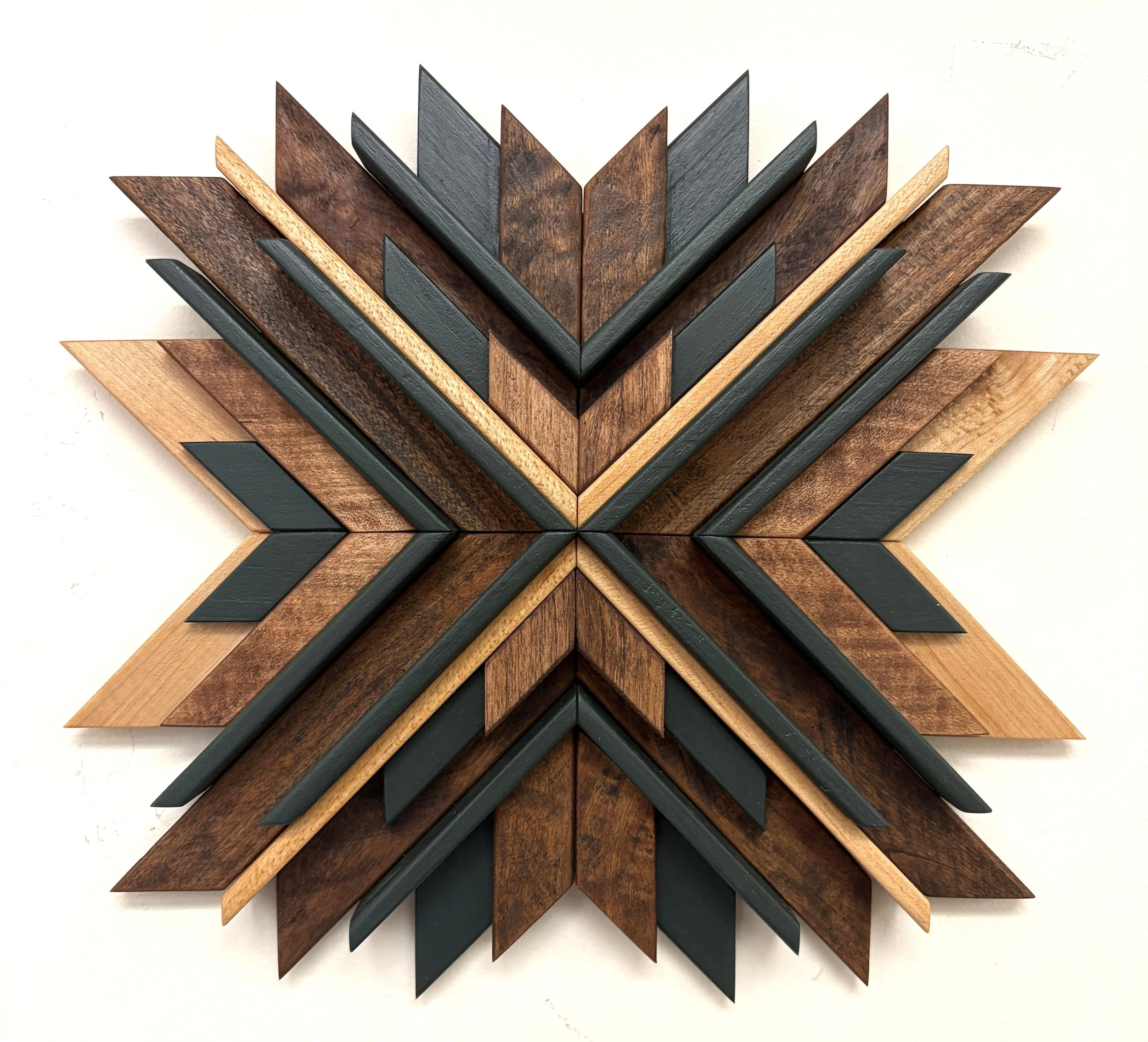 Wooden sunburst style mosaic in green paint with light and dark stains.