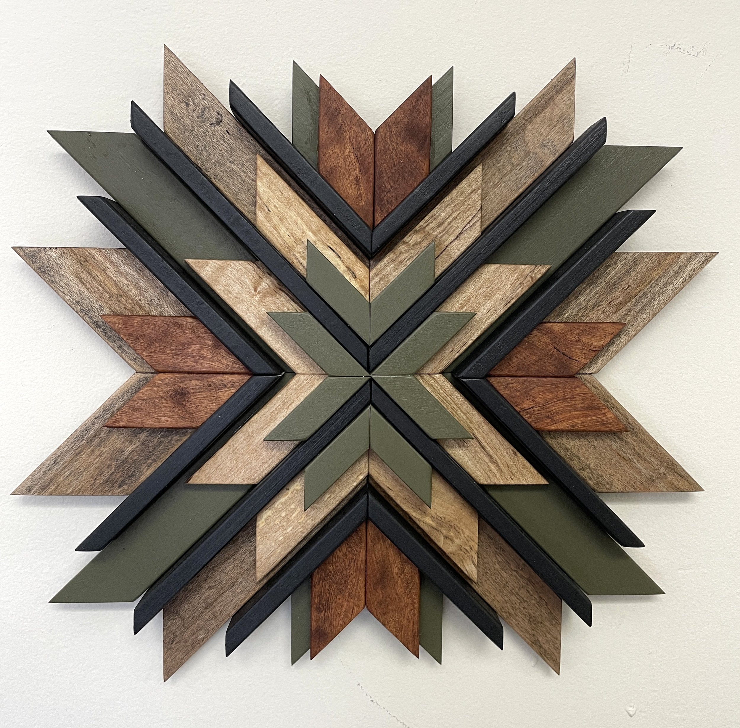 Handcrafted sunburst style wooden mosaic in black and green paint with natural and dark wood stains.