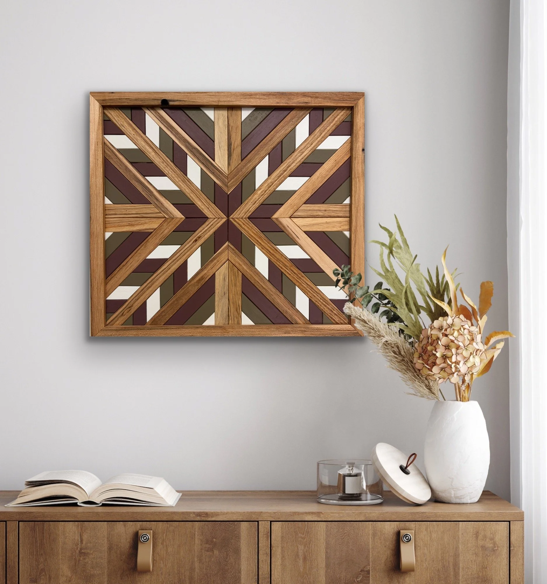 Handcrafted framed wooden mosaic in white, pink, and green paint with natural stains displayed on a wall.