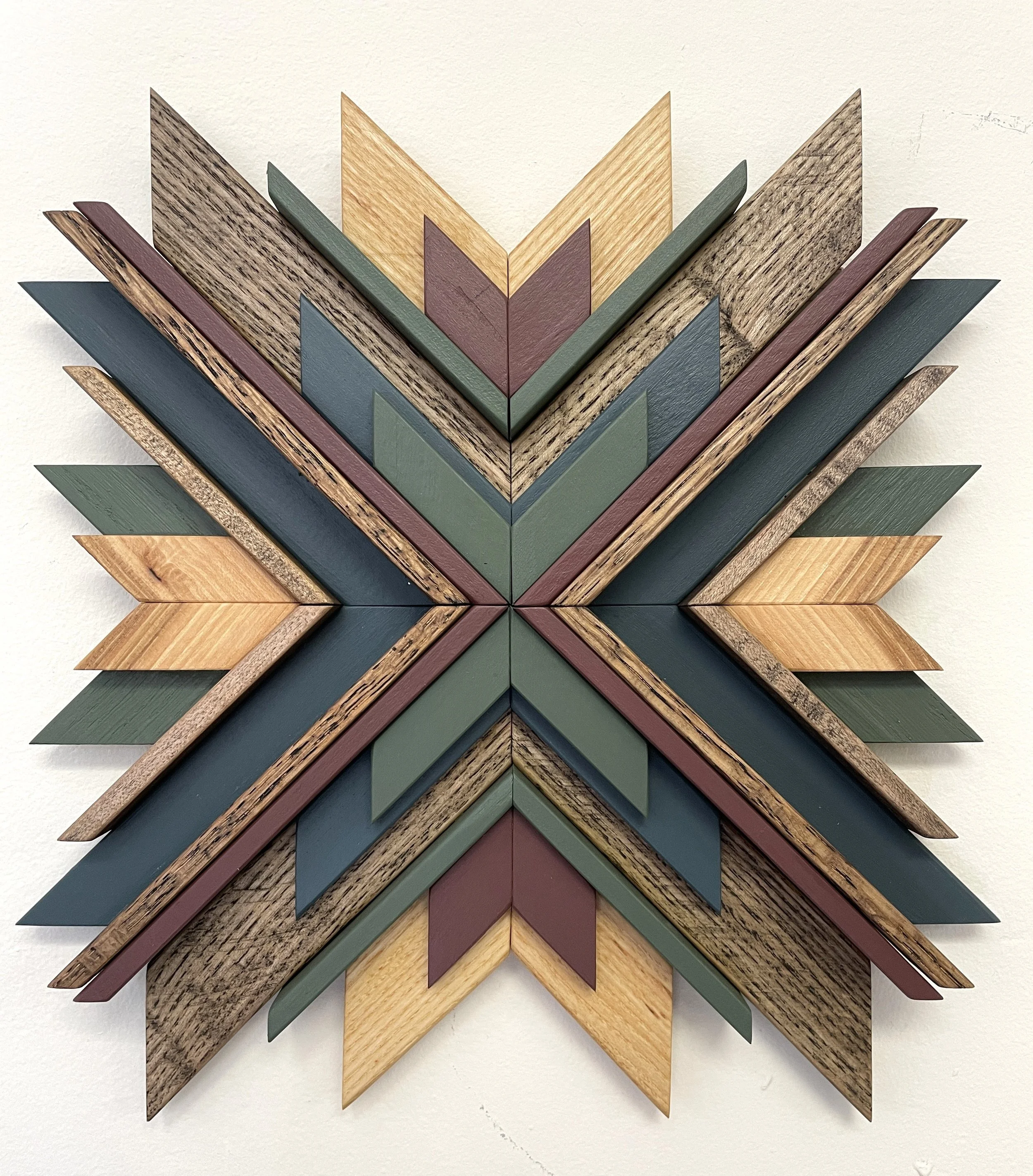 Handcrafted sunburst style wooden mosaic in pink, green, and blue paints with natural and espresso stains.