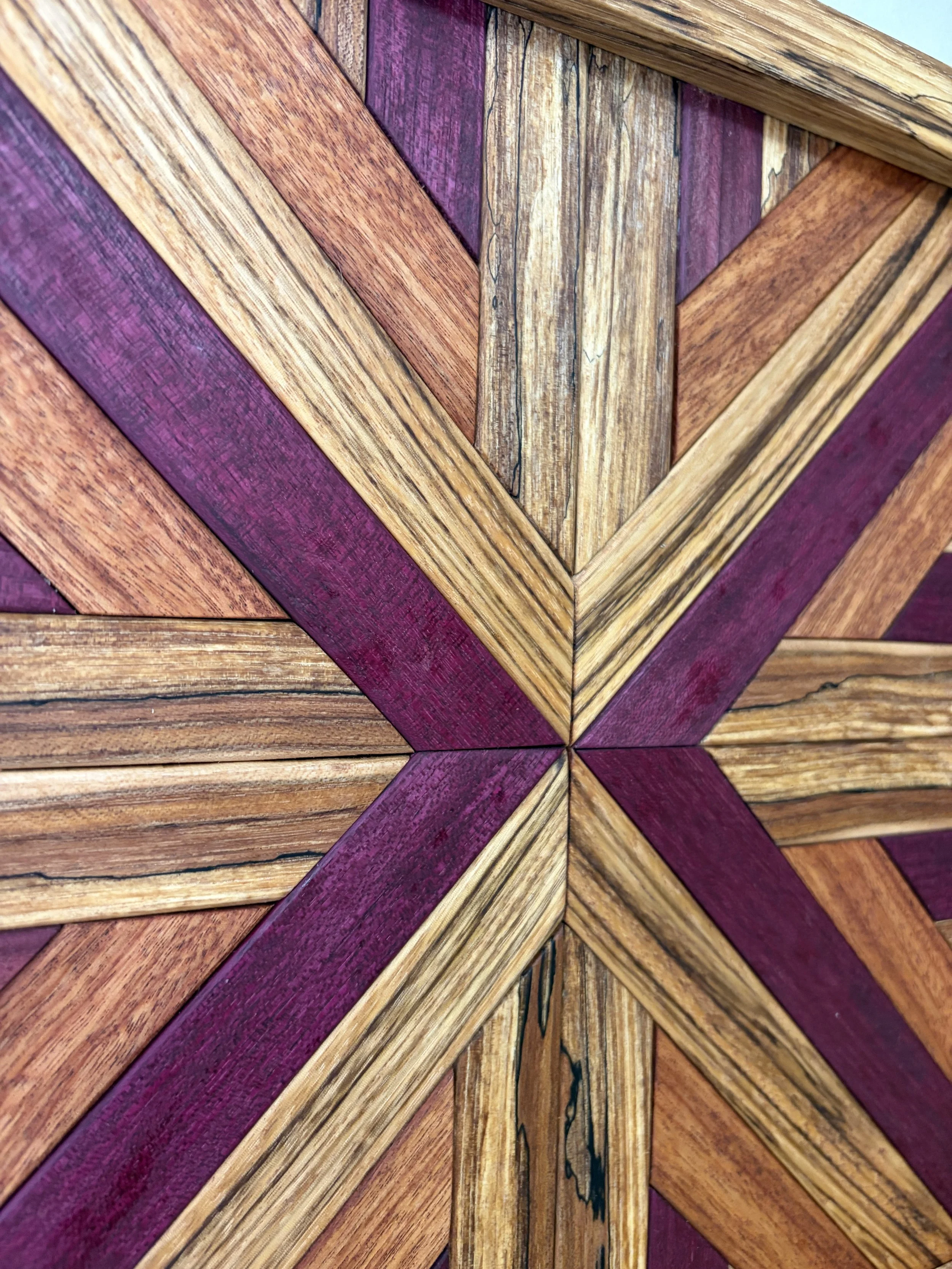 Close up view of a handcrafted framed wooden mosaic made from various exotic woods.