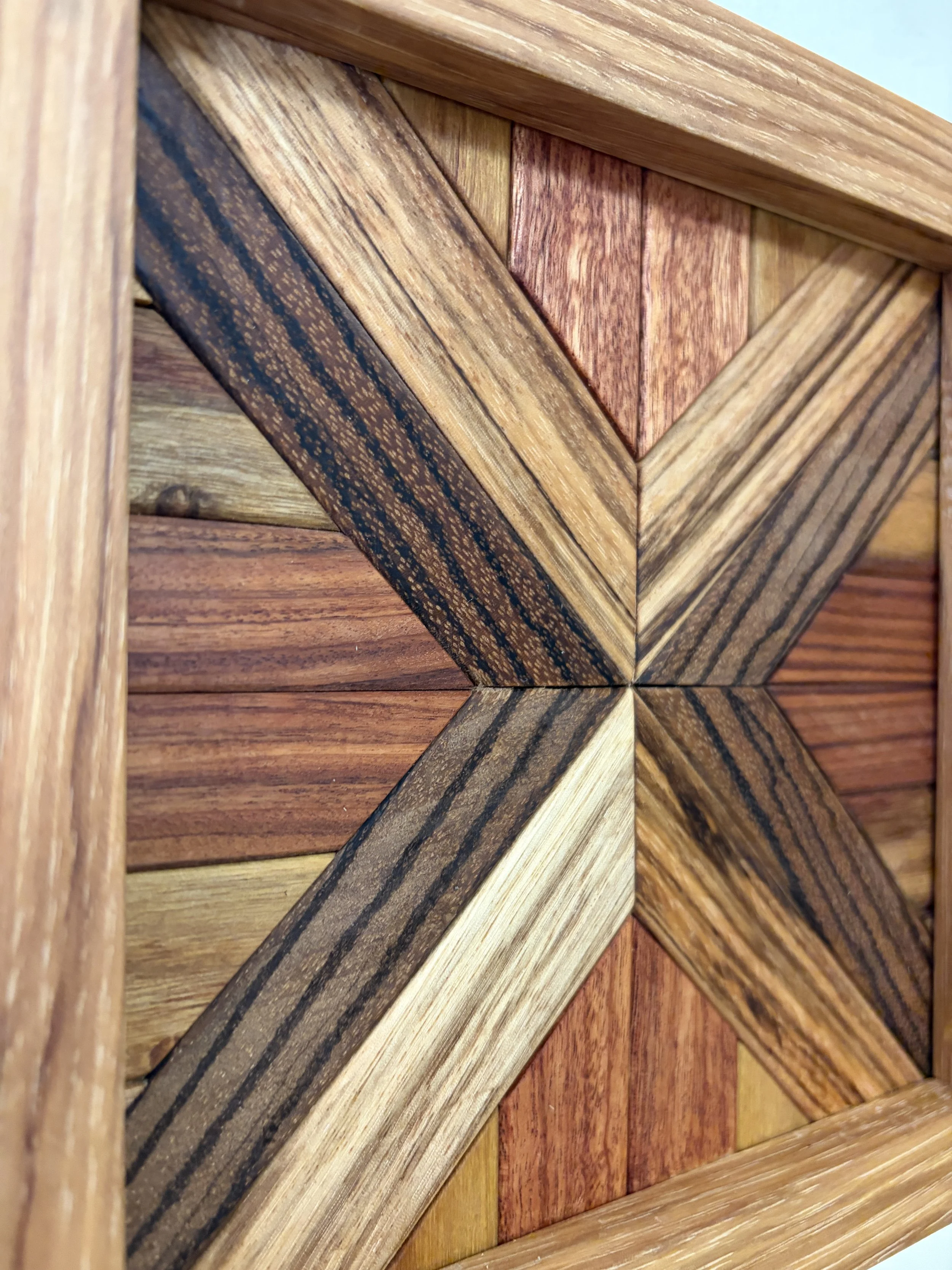 Detailed view of a handcrafted framed wooden mosaic made from various exotic woods.