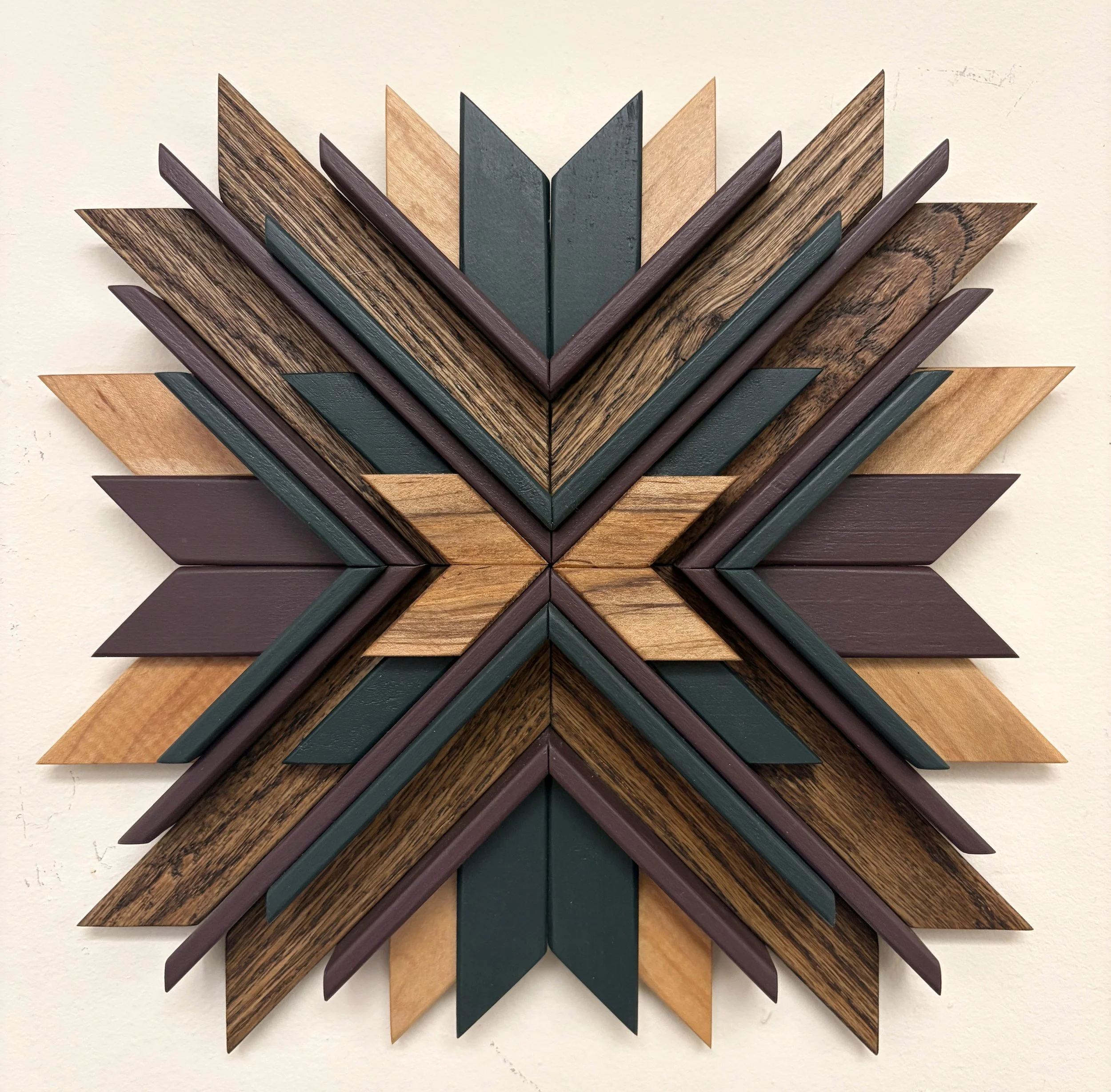 Wooden sunburst style mosaic in green and purple paint with natural and espresso stains.