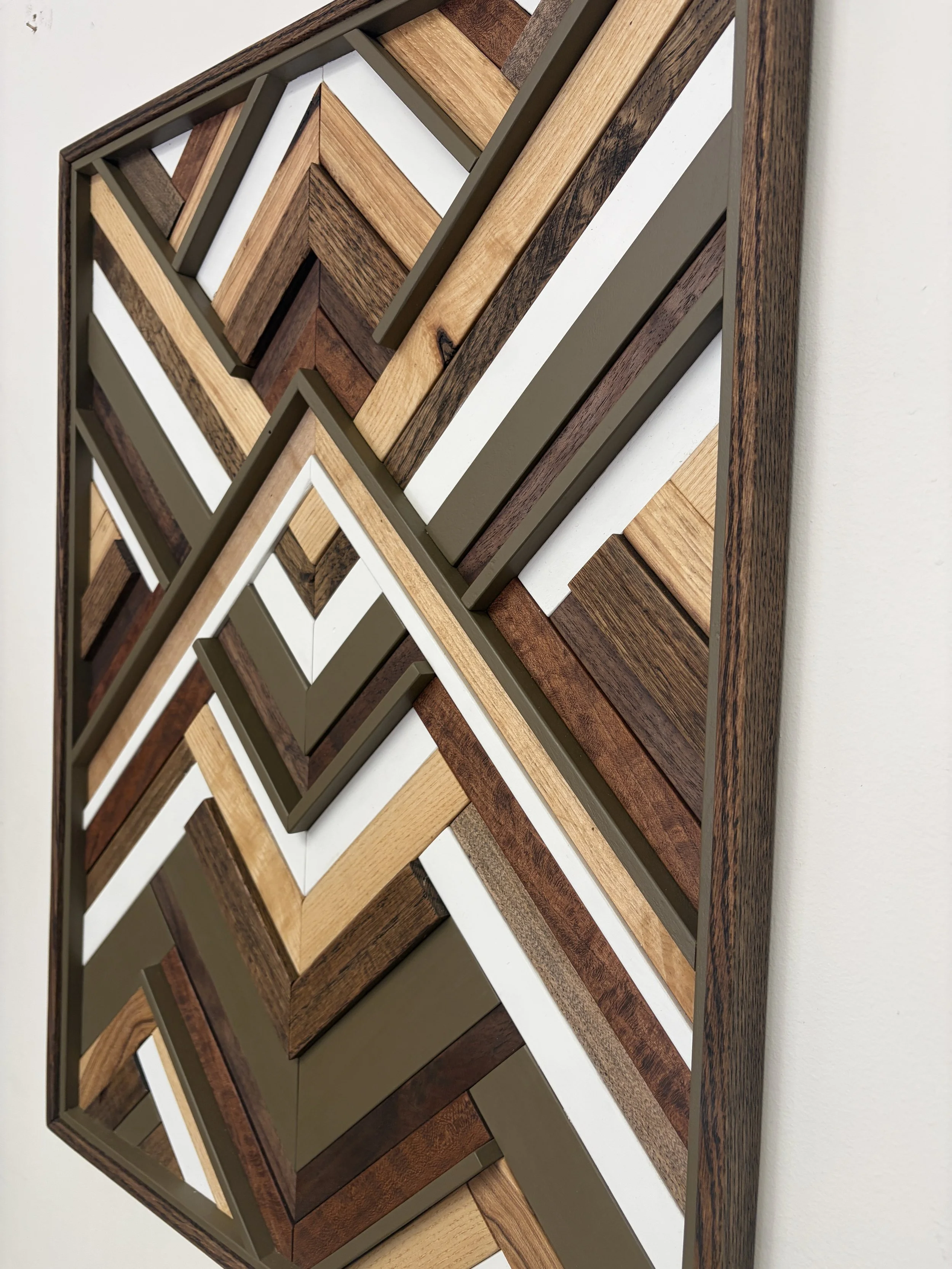 Side view of a handcrafted framed wooden mosaic in white and light olive green paint with natural, espresso, and red mahogany stains.