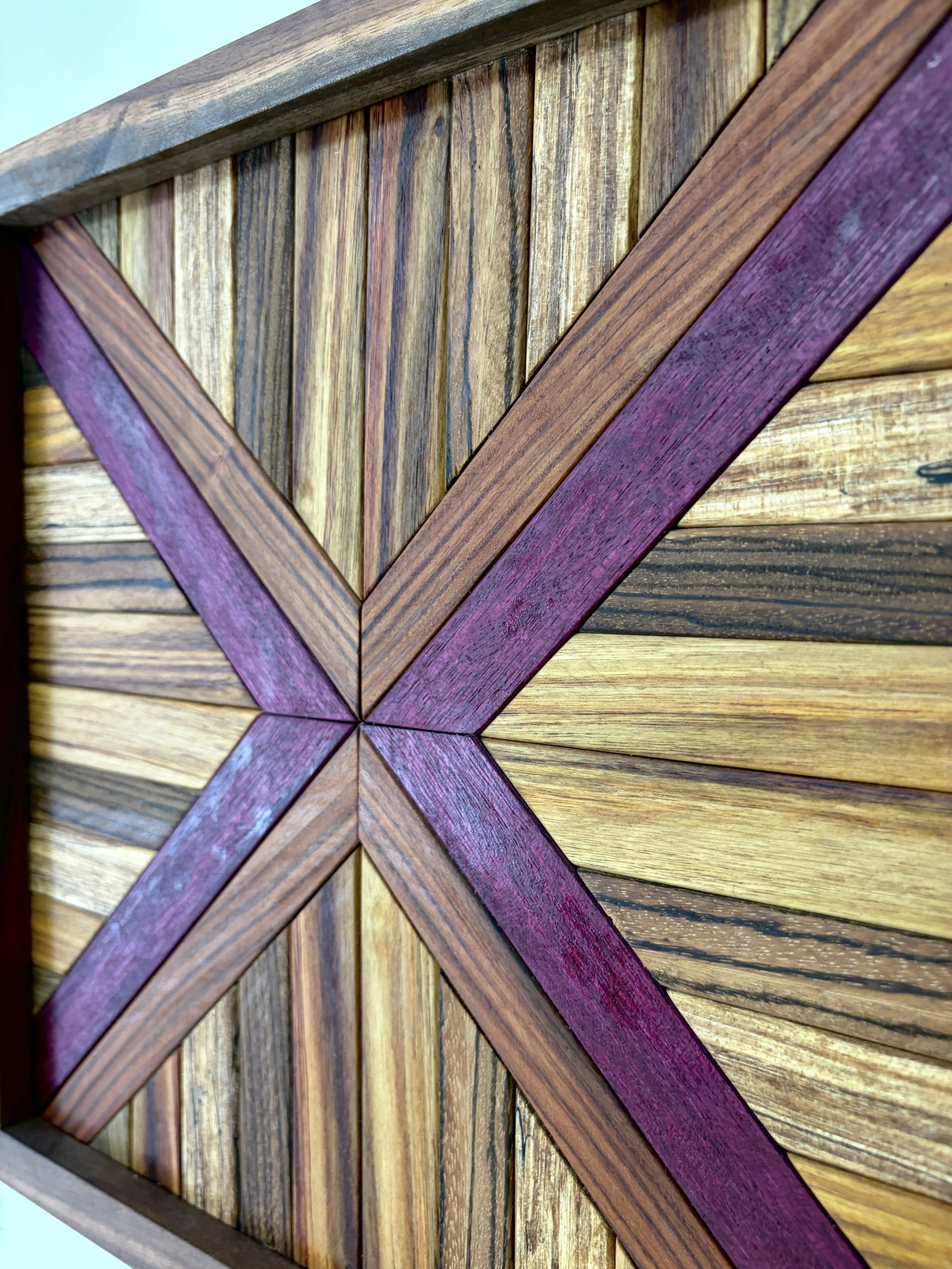 Close up view of a handcrafted framed wooden mosaic made from various exotic woods.