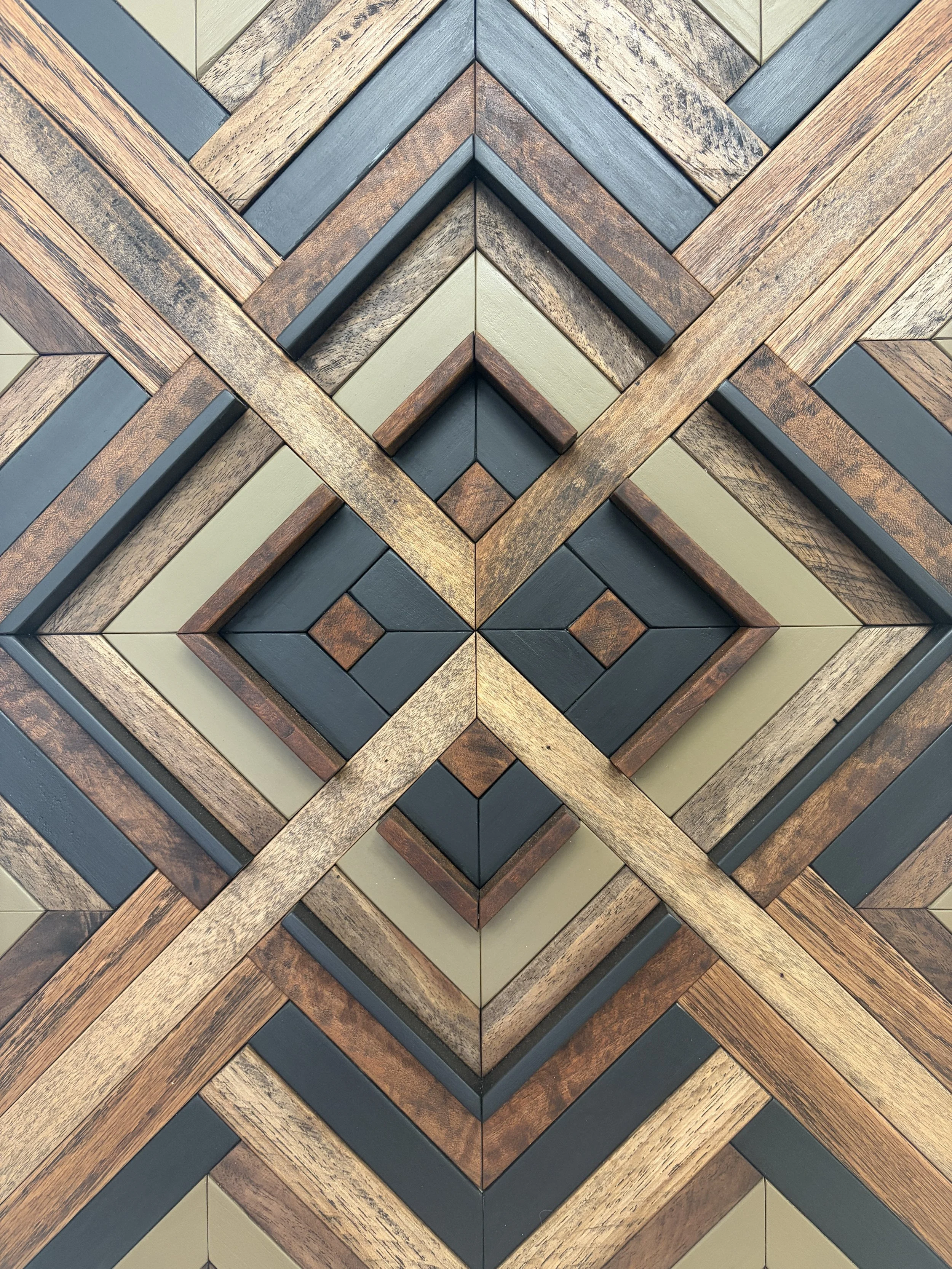 Detailed view of a handcrafted framed wooden mosaic in black and green paint with an espresso stains.