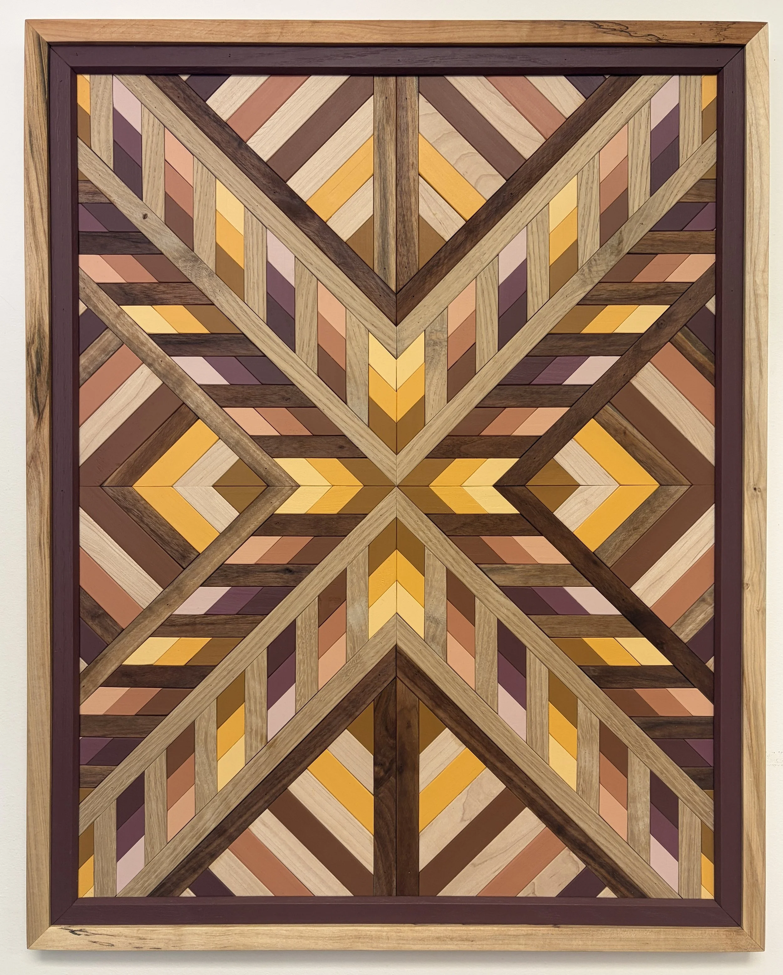 Handcrafted framed wooden mosaic in several shades of pink, orange, and yellow paint with natural stains.