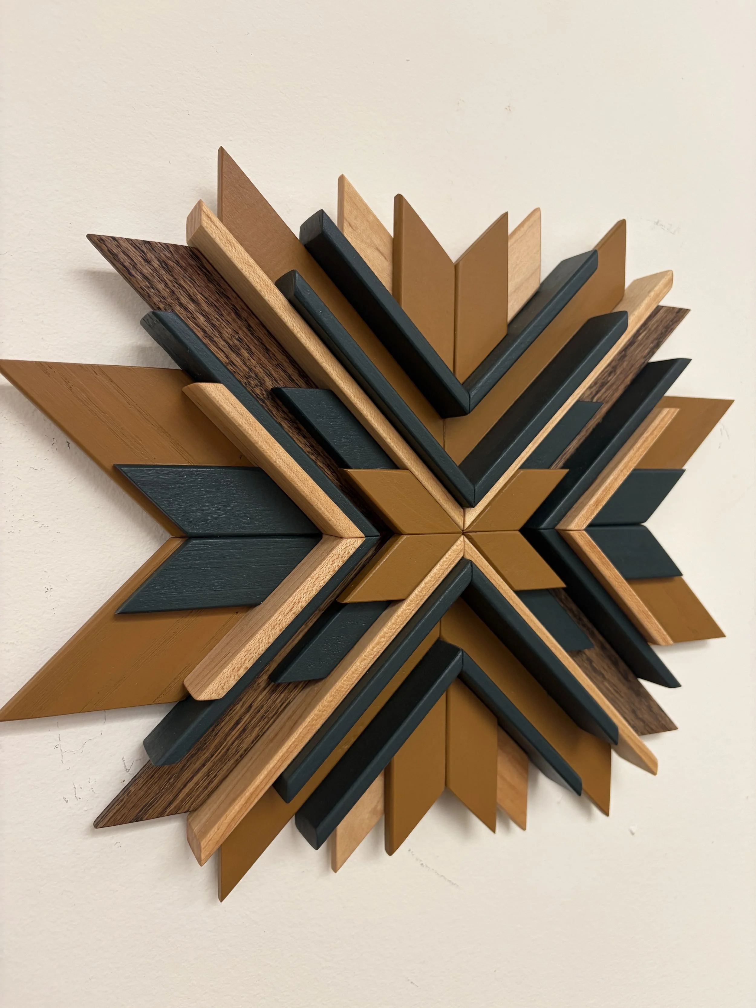 Angled view of a wooden sunburst style mosaic in green and yellow paint with natural and espresso stains.