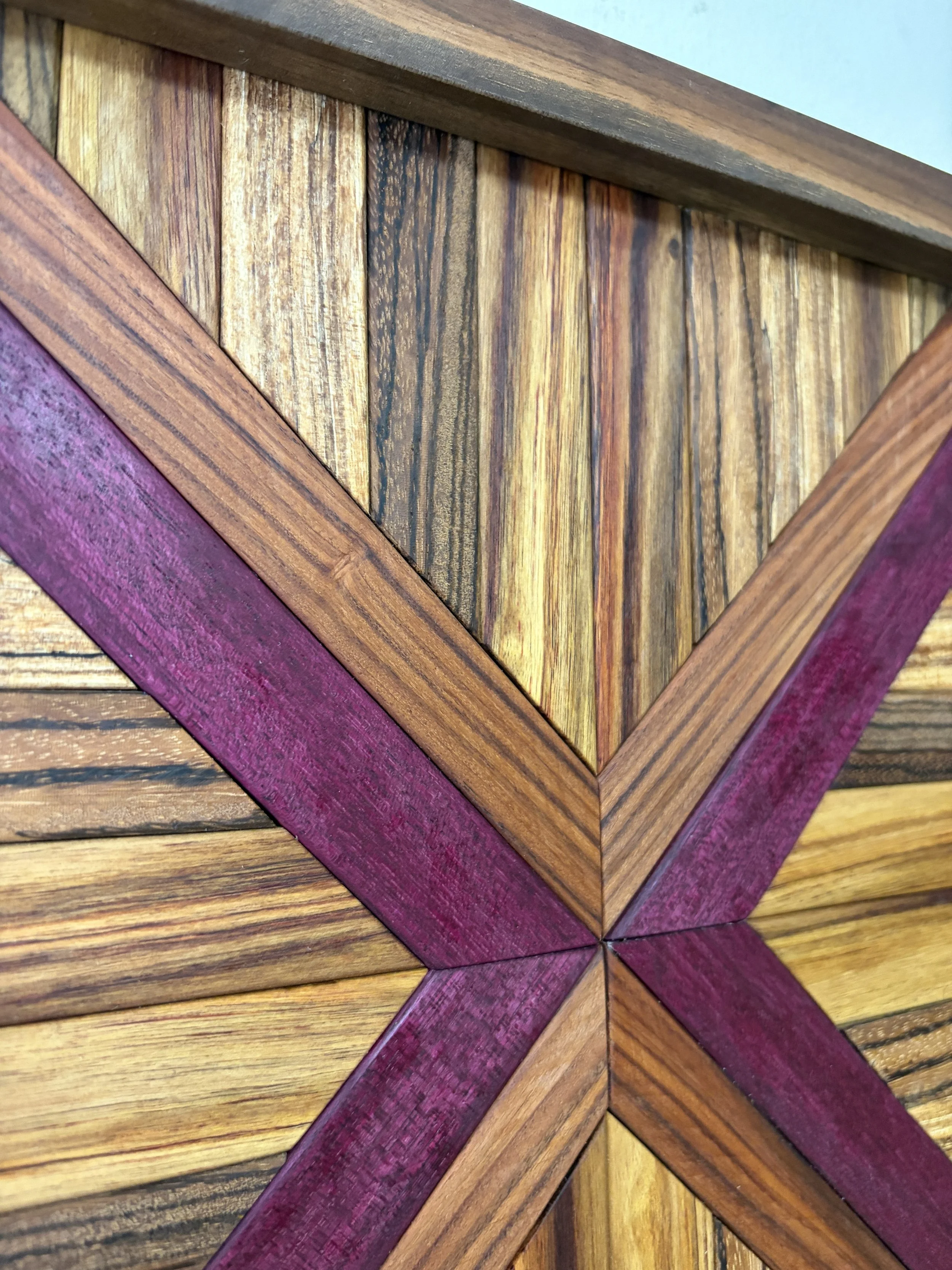 Detailed view of a handcrafted framed wooden mosaic made from various exotic woods.
