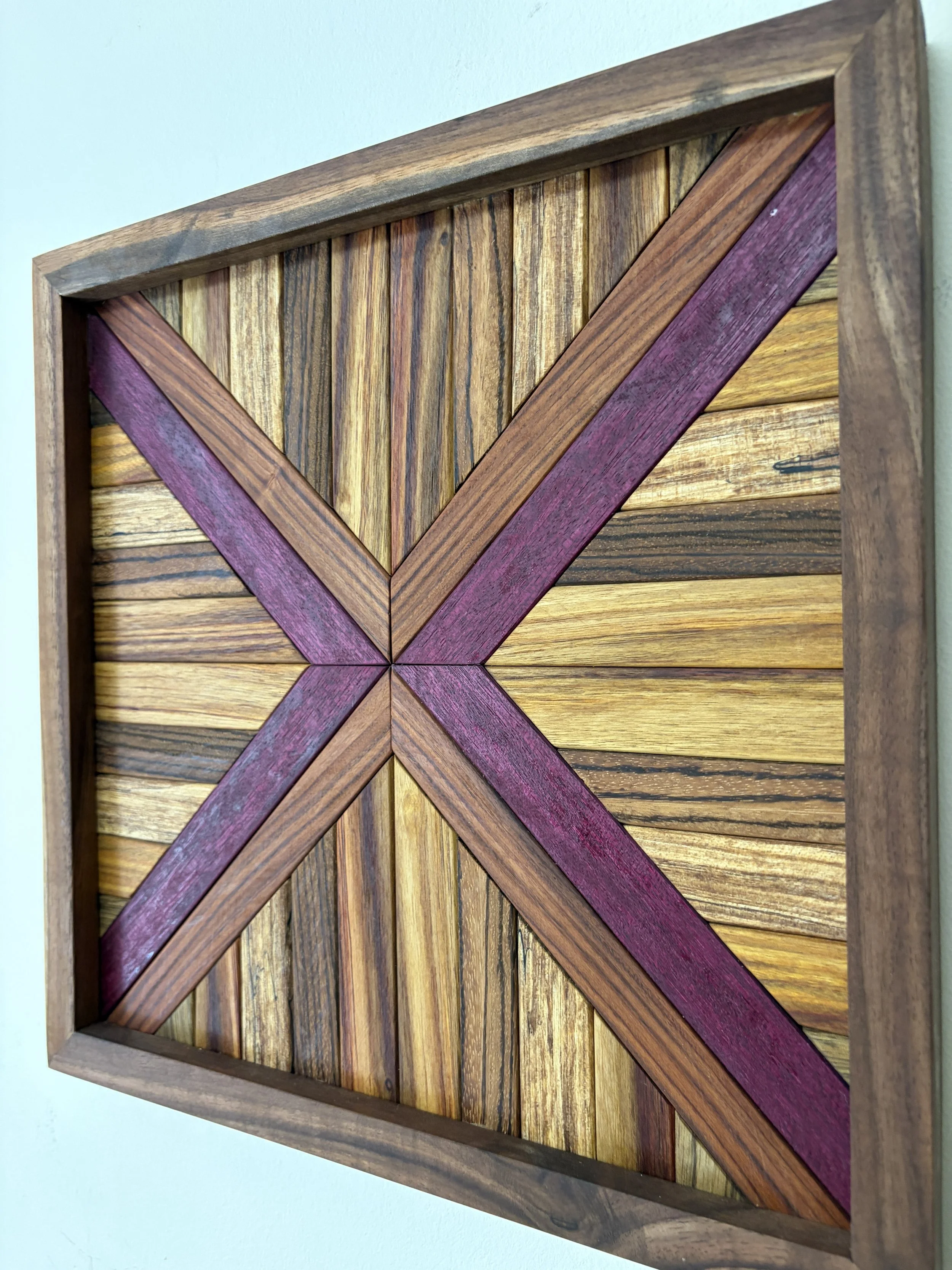 Angled view of a handcrafted framed wooden mosaic made from various exotic woods.