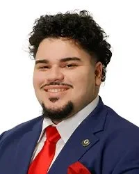 Portrait of a woman wearing glasses and pearl necklace, labeled as Commissioner Ms. Valerie Freeman.