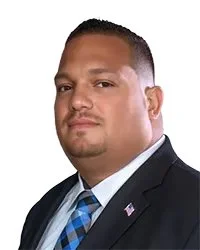 Portrait of a woman in a blue blazer with the text 'Commissioner Ms. Della McCall' below her.