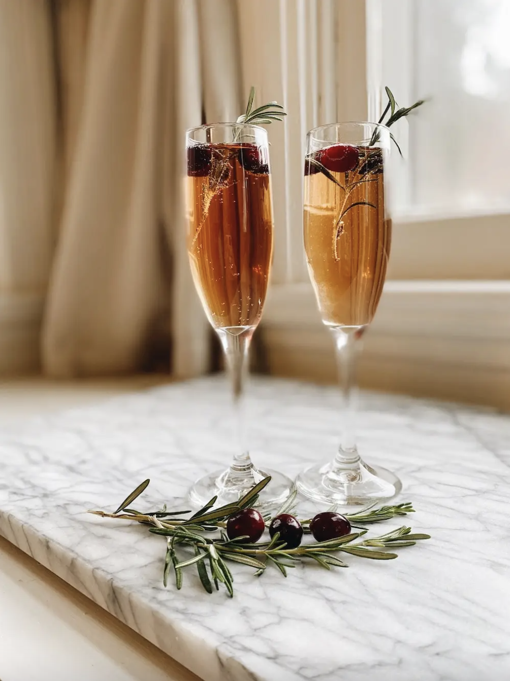 Two cranberry mimosas on a slab of marble