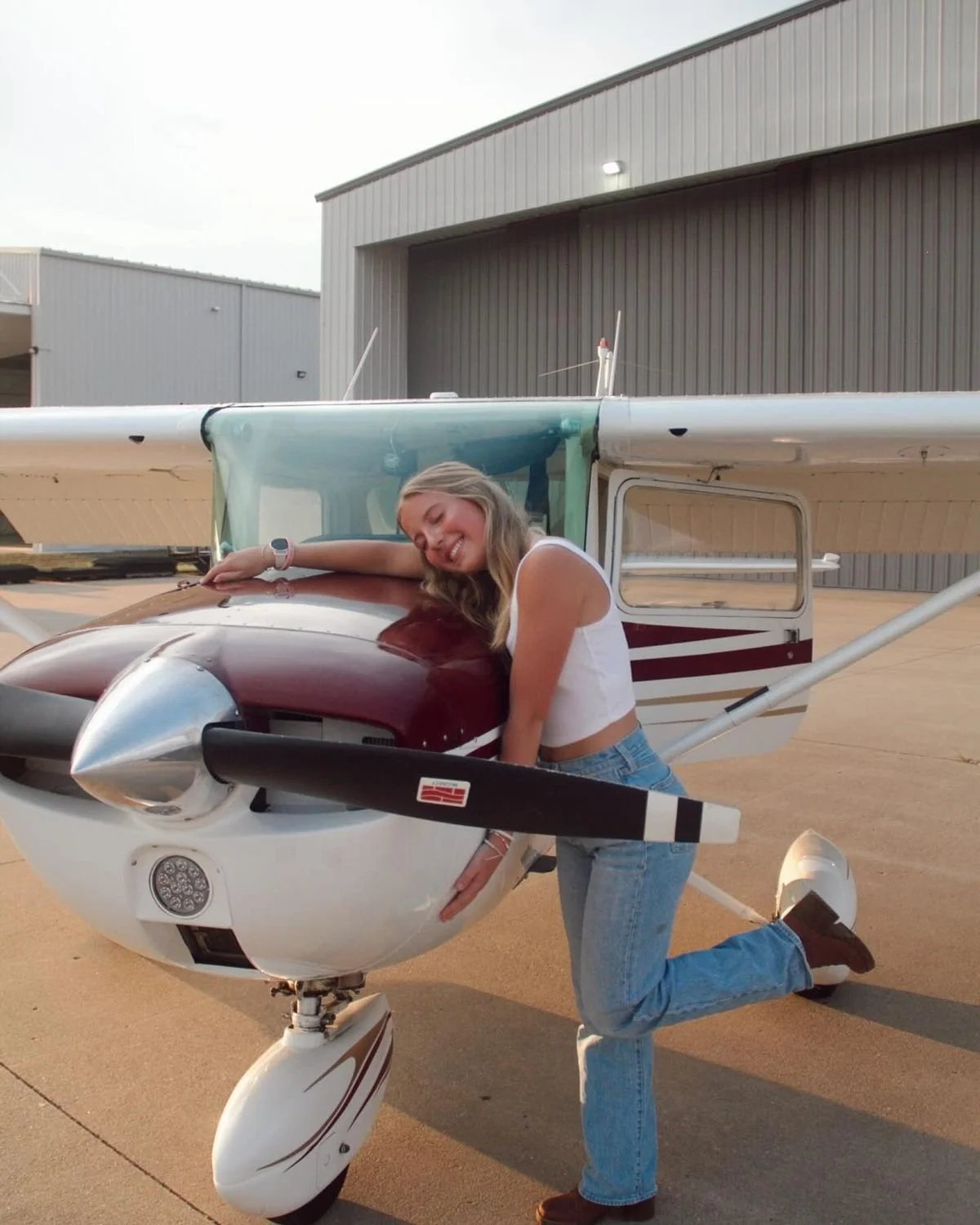Pose direction:
“Lean into the front of the plane and wrap your arms around it gently like you love this part of your story. Kick one heel up behind you and give me a playful smile.”

Movement cue:
“Lean in, kick the heel up, then laugh like it feels