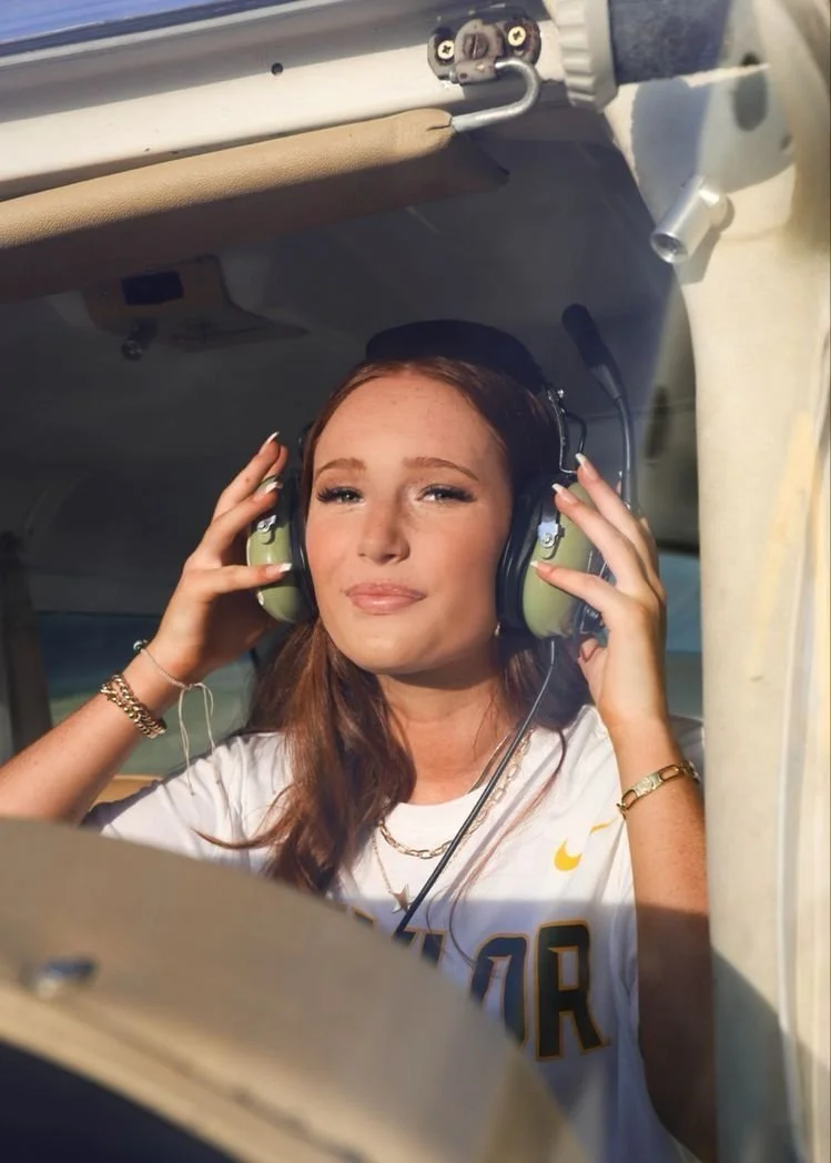 Sit in the cockpit and bring both hands up to the headset like you’re getting ready to fly. Look out the window first, like you’re checking the ramp, then slowly bring your eyes back toward me