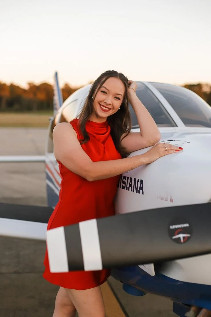 Pose direction:
“Rest one forearm gently on the nose of the plane and bring your other hand into your hair. Keep your shoulders relaxed and lean in slightly like it’s an effortless editorial portrait.”

Movement cue:
“Brush your hair back slowly, the