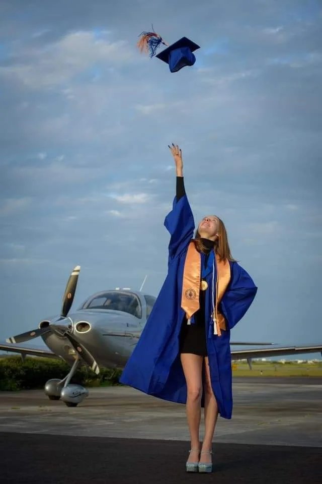 Stand tall, hold your cap low first, then toss it straight up. Reach your hand toward it and keep your body long. Look up at the cap. toss high, reach up, keep smiling through the whole motion.”