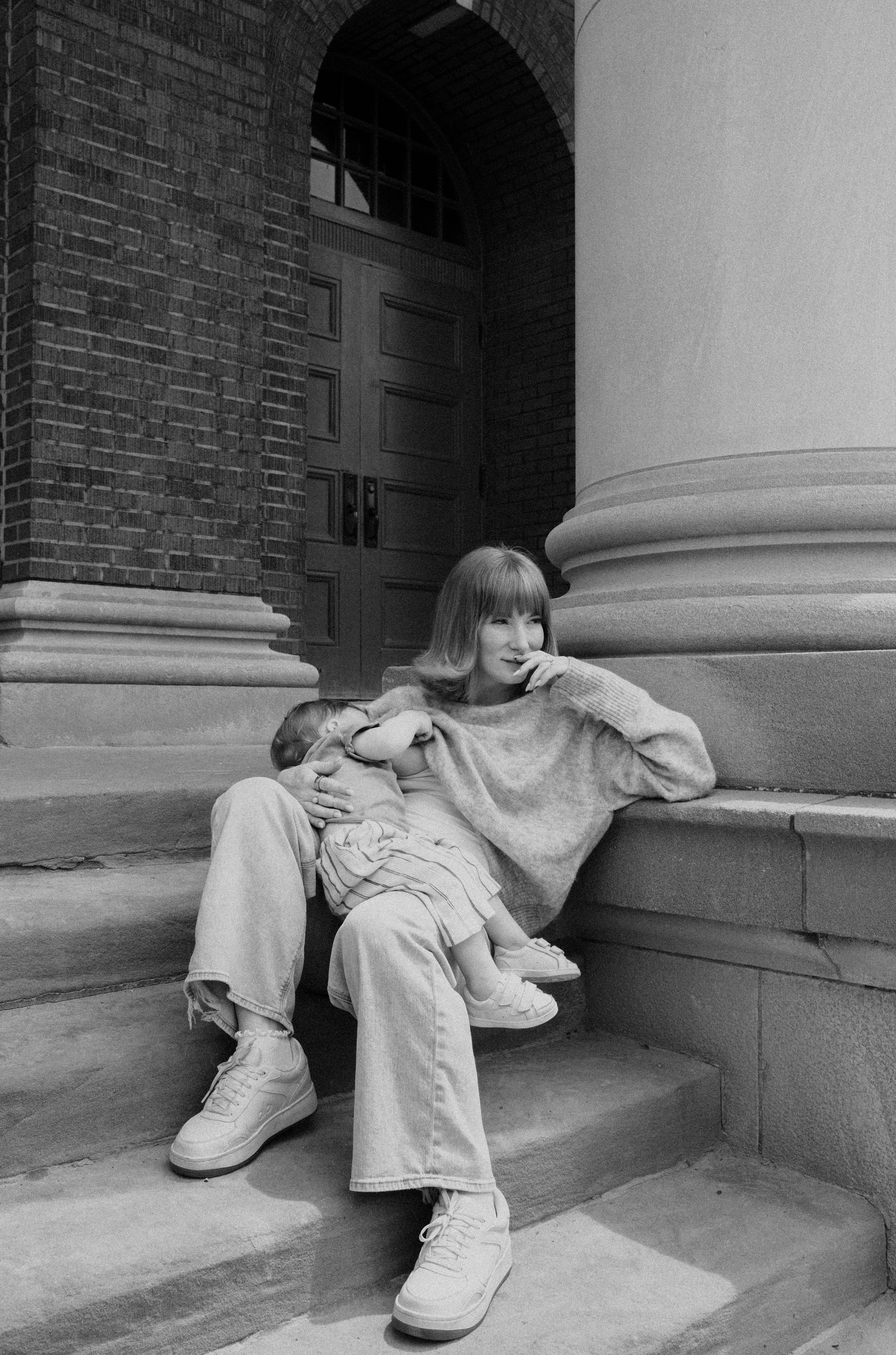 mom and baby nursing on concrete step