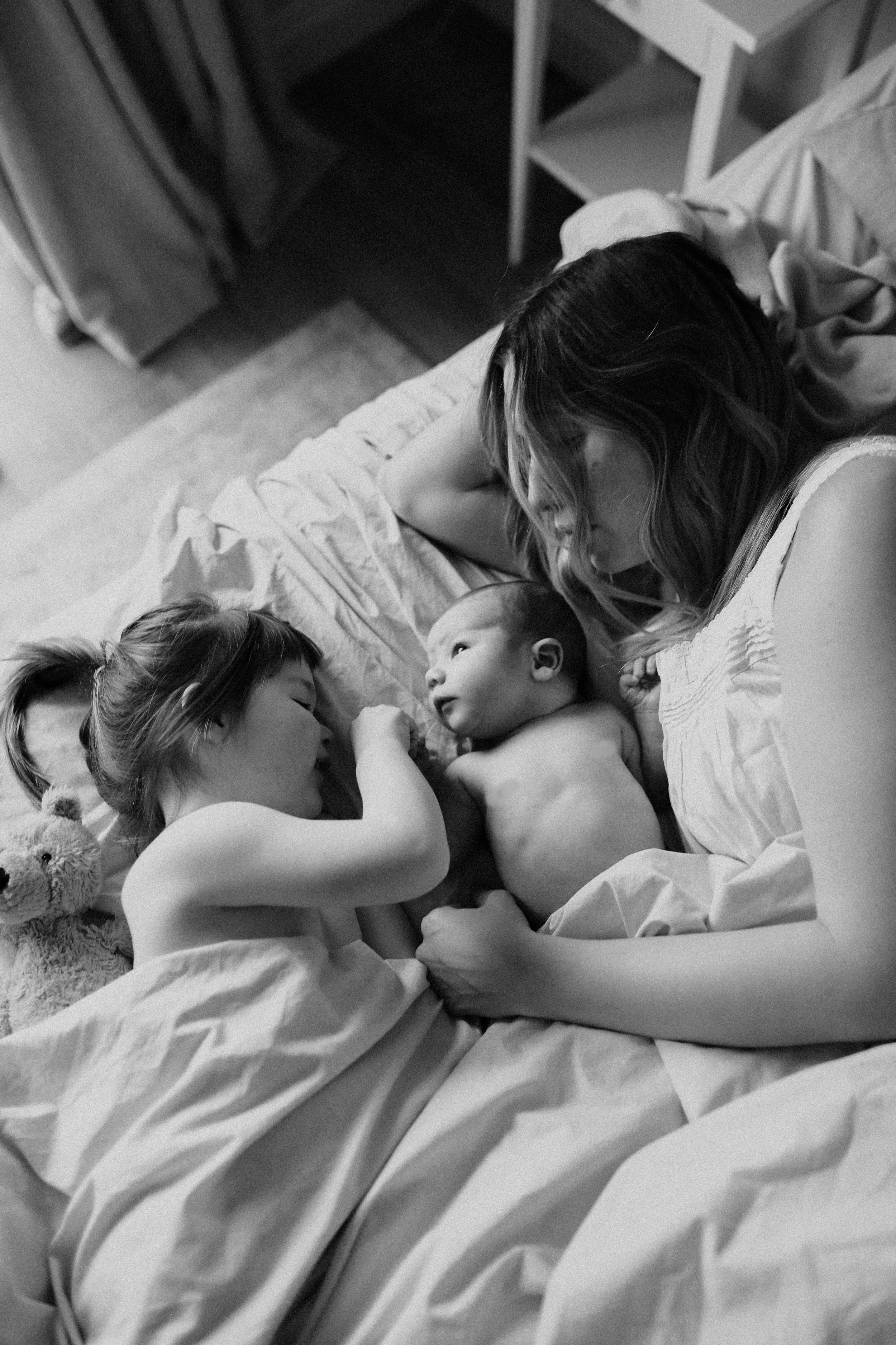 mom in bed with baby during newborn session