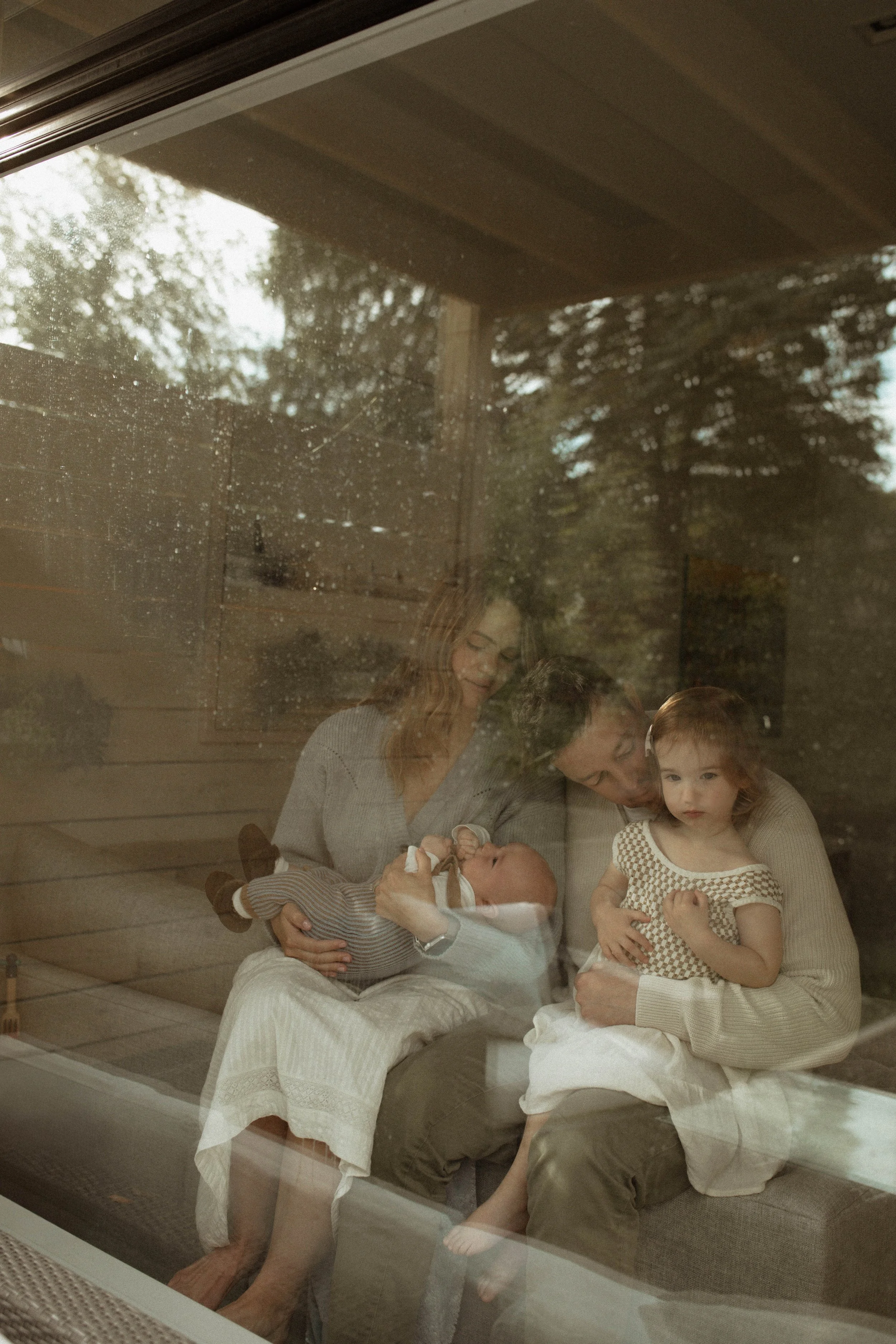 family sitting in the window during photography session