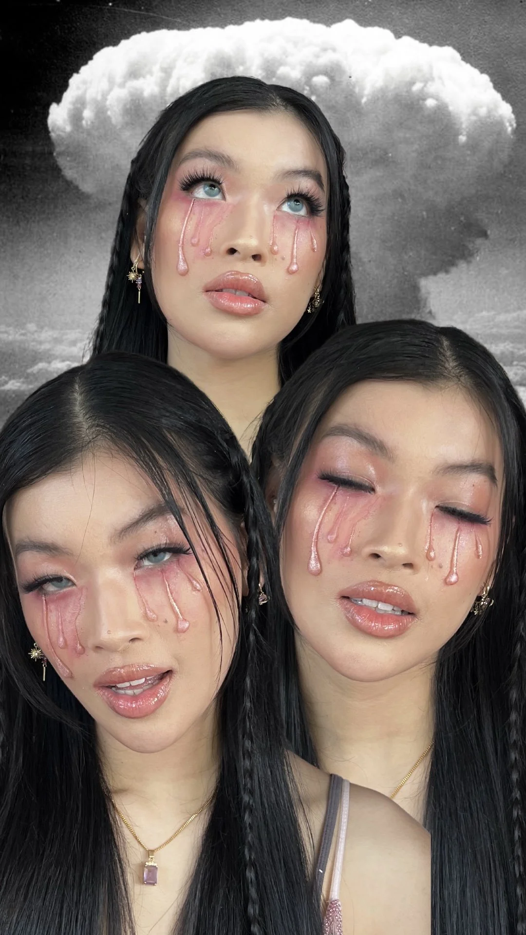 Three women with black hair and pink makeup, with tears of pink liquid on their faces, are posing in front of a black and white cloud background. The woman in the center has her eyes open, looking upward, while the other two have both eyes closed, wi