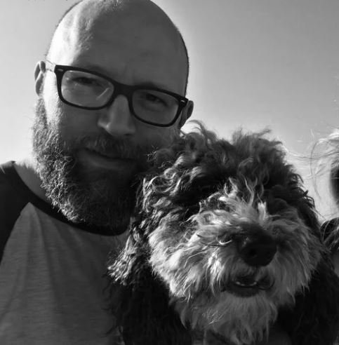 Jim in a head an shoulders portrait with his dog