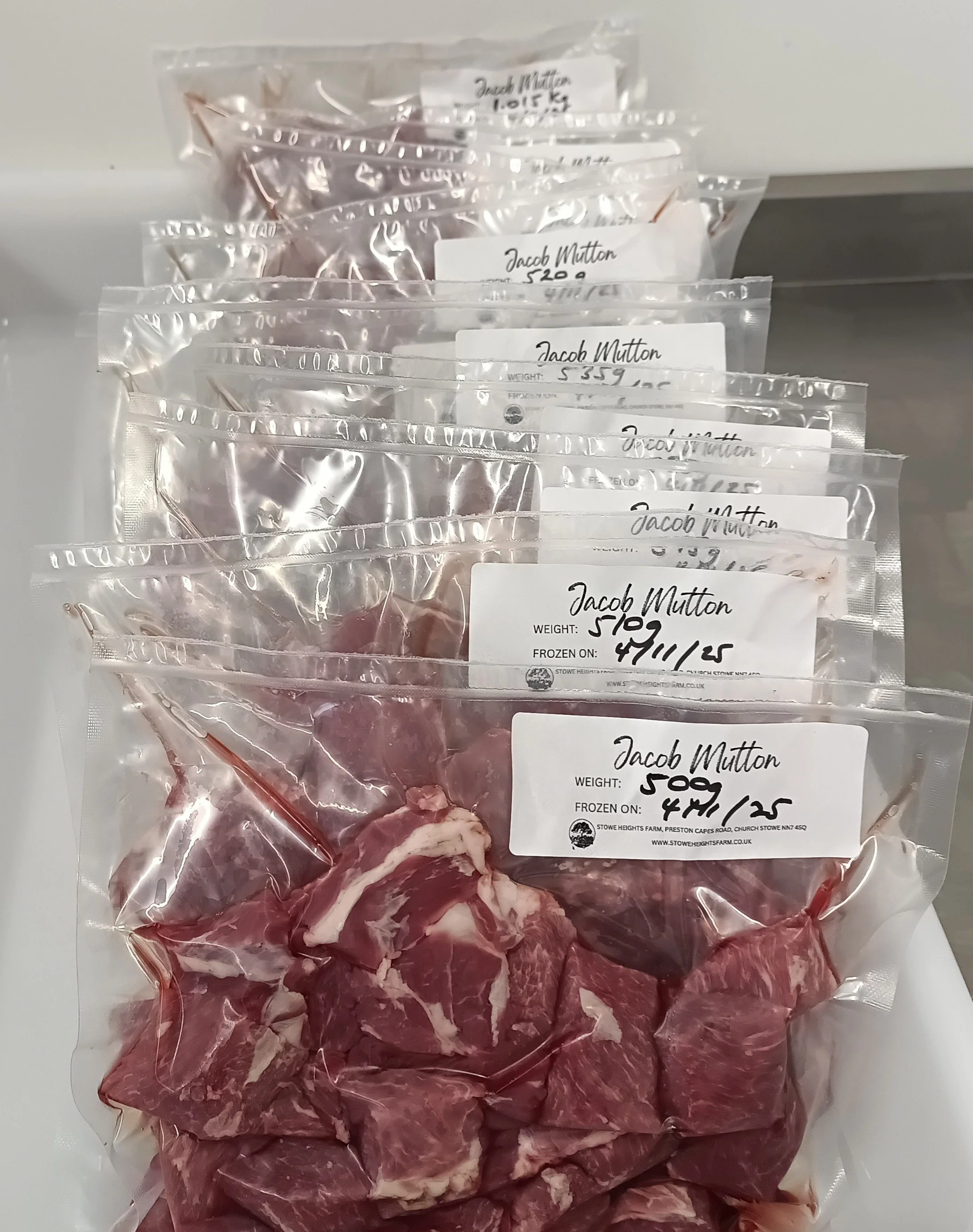 Several packages of frozen Jacob Mutton meat with handwritten labels indicating weight and date.