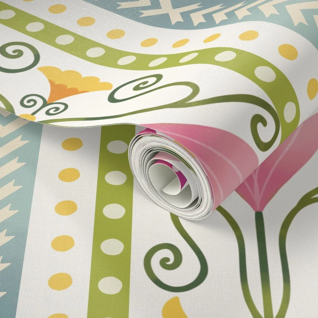 Close-up of a rolled-up sheet of colorful wallpaper with floral and decorative patterns in pink, green, blue, and yellow.