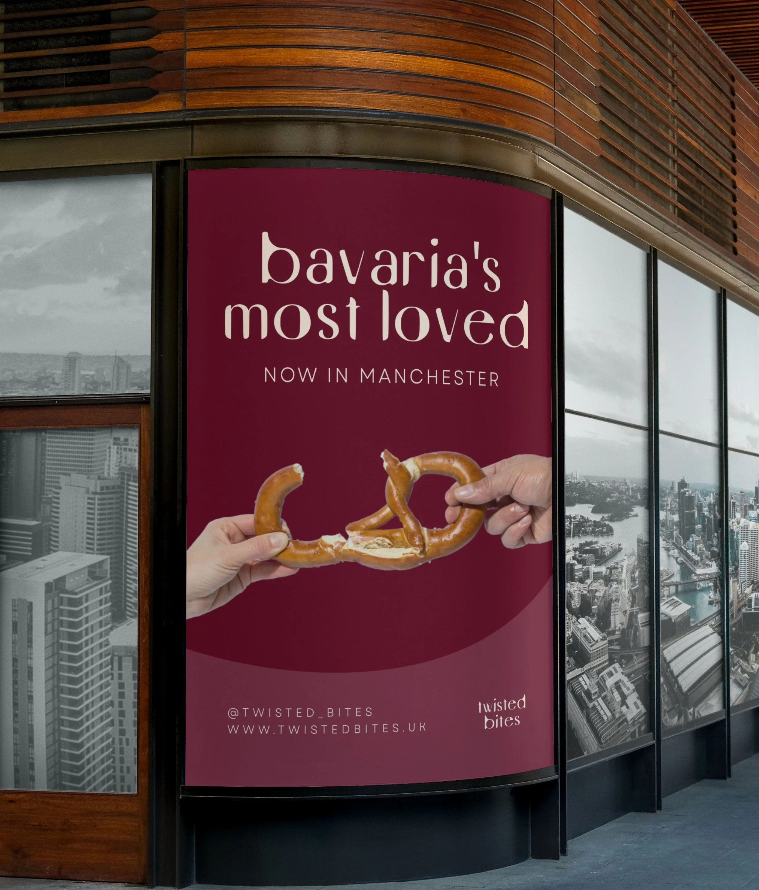 Advertising board for Twisted Bites, a food establishment now open in Manchester. The board features a hand holding a pretzel with a cityscape in the background.