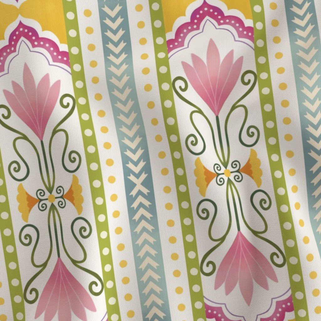 Colorful patterned fabric with pink floral motifs, green, yellow, blue, and purple decorative borders, and symmetrical designs.
