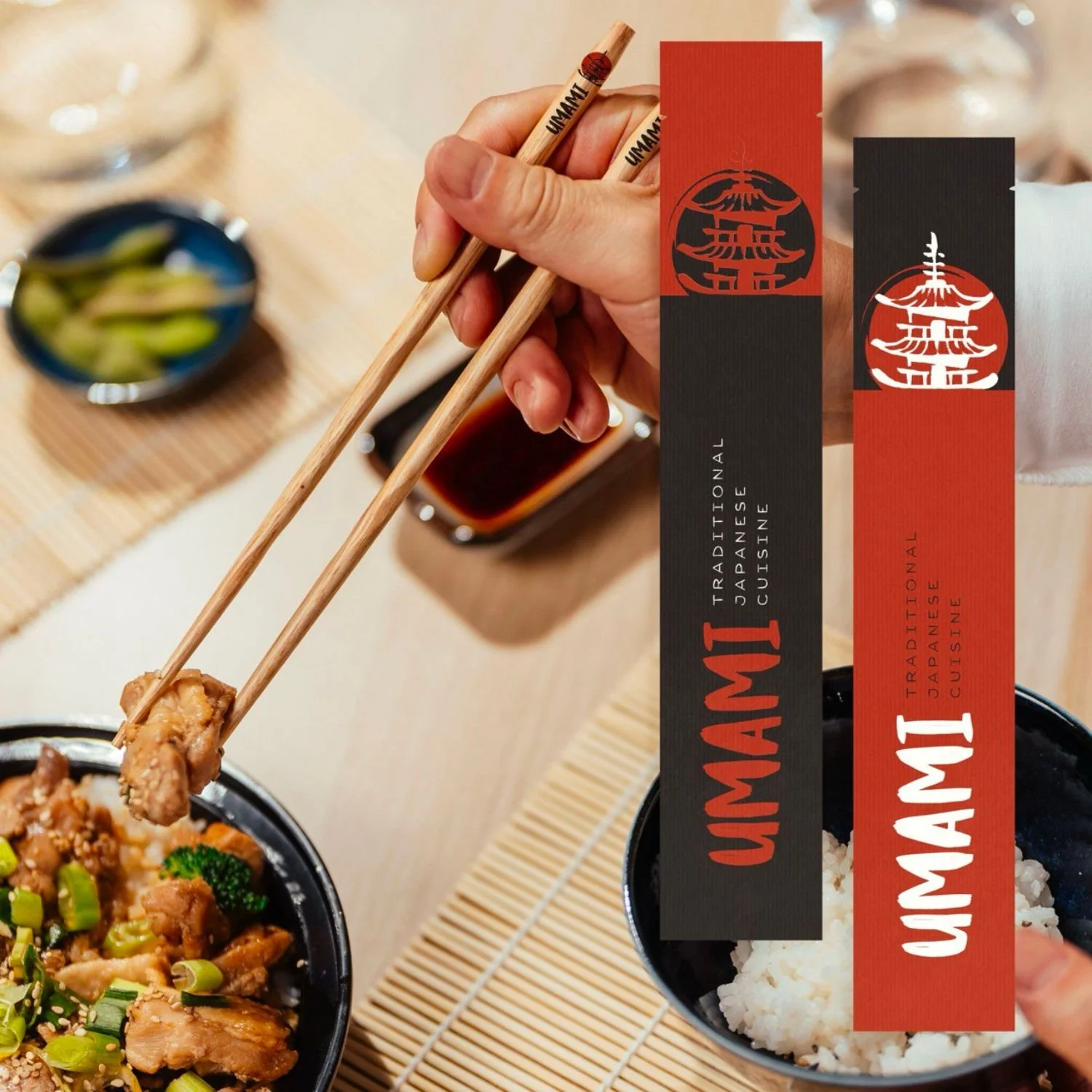 Close-up of a hand using chopsticks to pick up a piece of food from a bowl of Asian cuisine. In the background, there are bowls of rice and other dishes on a bamboo placemat.
