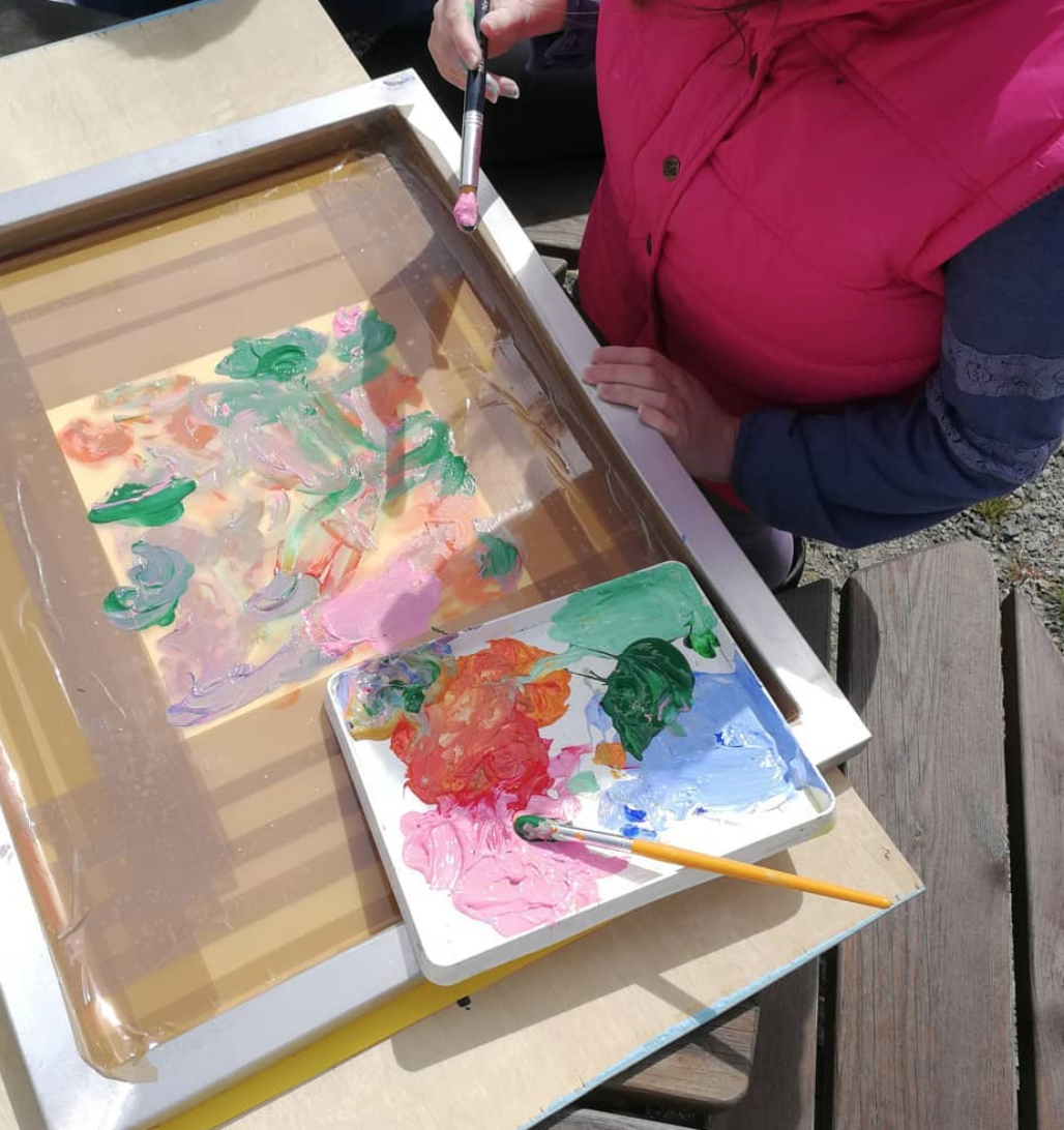 Artist Mari Johnson working on some silkscreen paintings in her garden