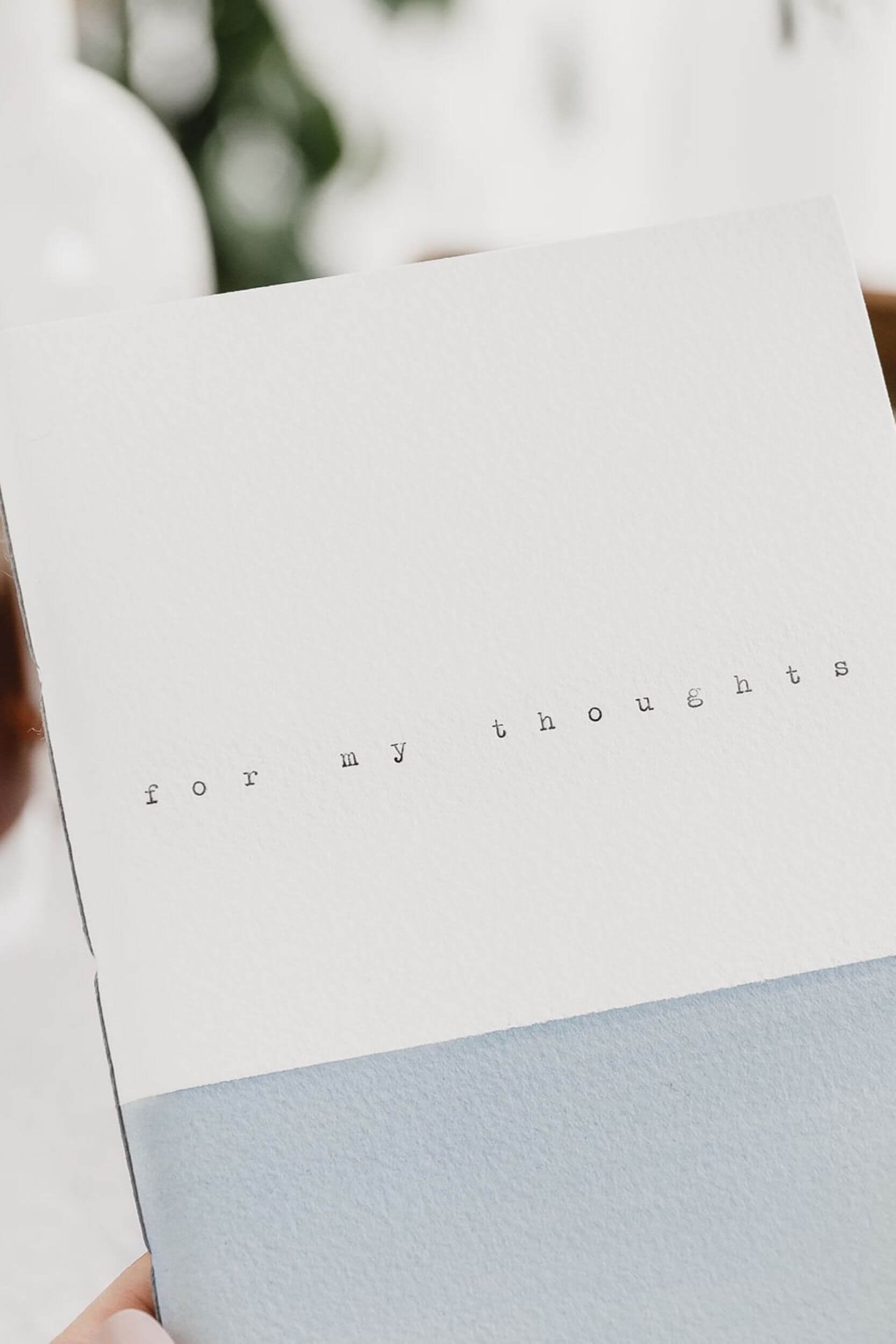 close up of grey and white notebook with the text 'for my thoughts' on the cover