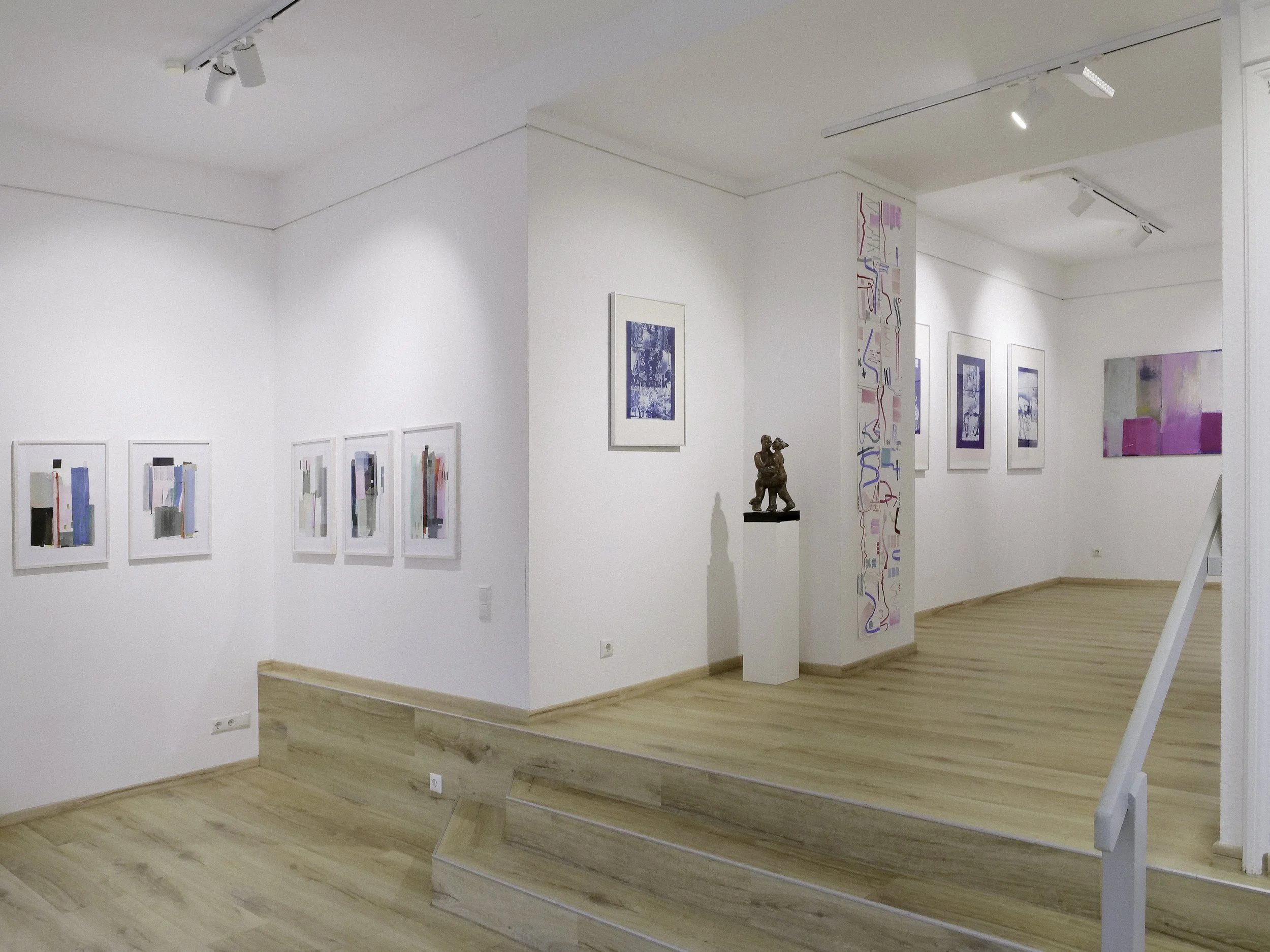 Kunstgalerie mit weißen Wänden, mehreren abstrakten Gemälden und Skulptur auf einem weißen Podest, Holzfußboden.