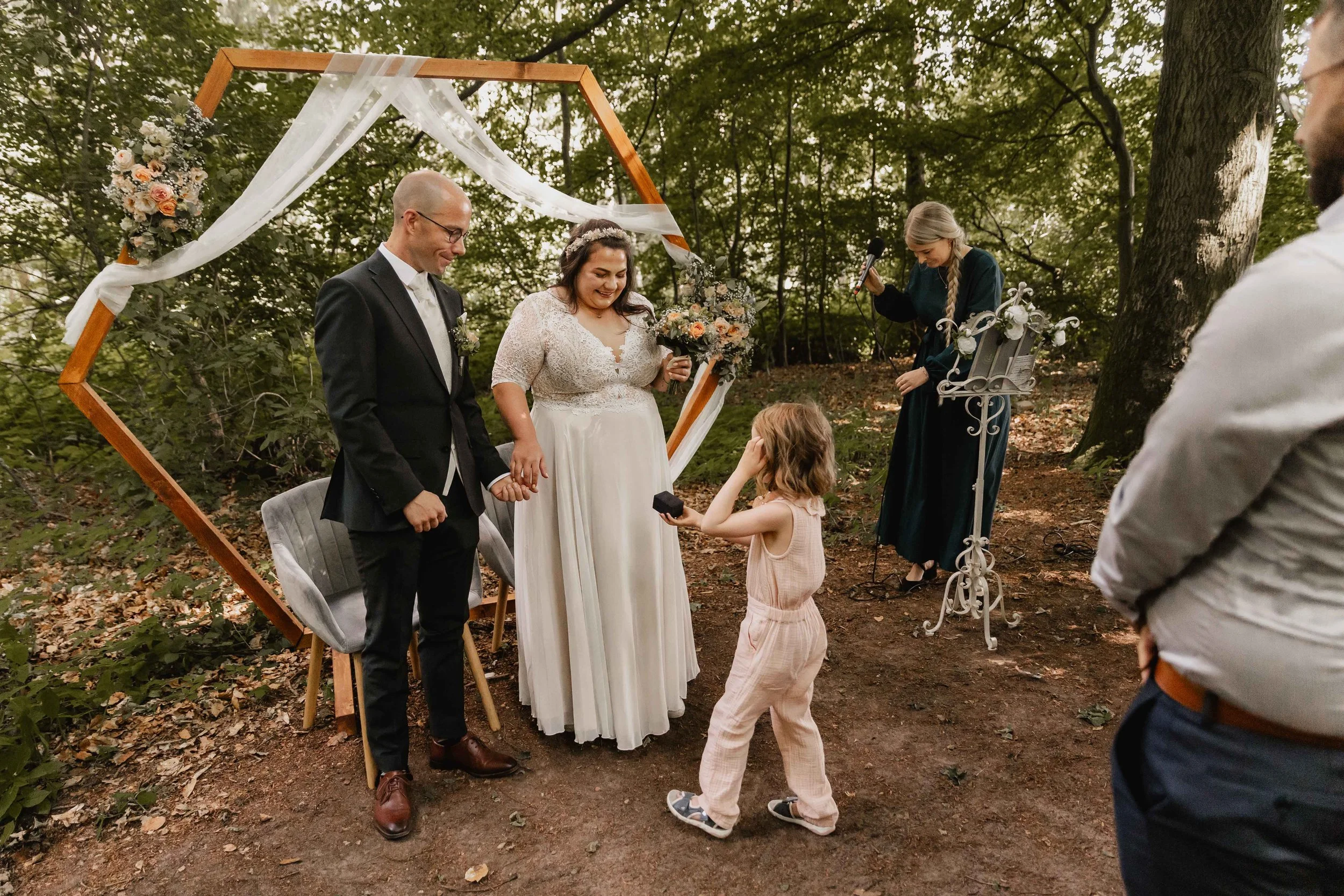 Kleines Mädchen überreicht die Ringe bei der Hochzeit im Wald
