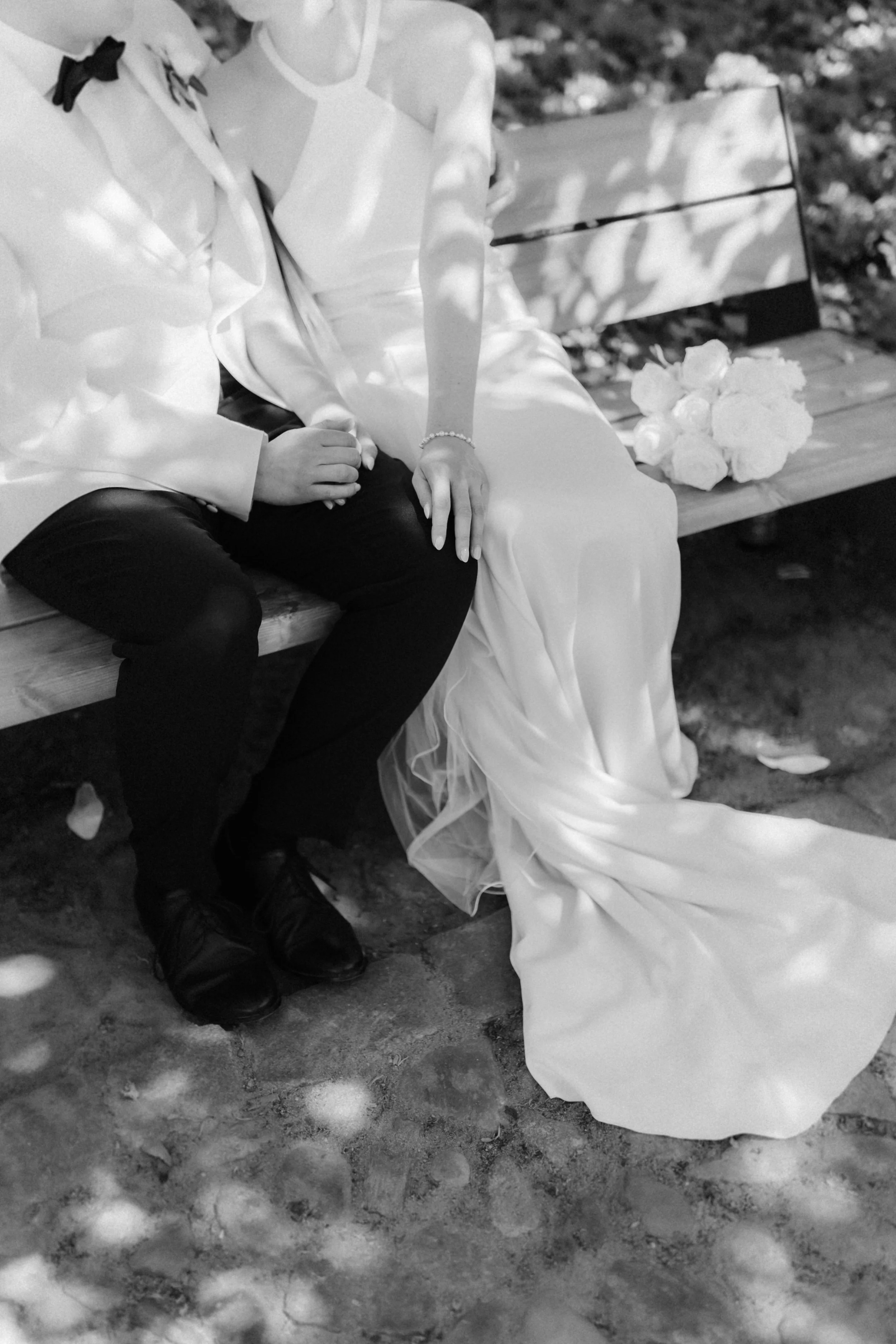 Detailaufnahme von Brautkleid, Brautstrauß und den Händen des Brautpaares bei ihrer Hochzeit im Rathausgarten in Lüneburg.