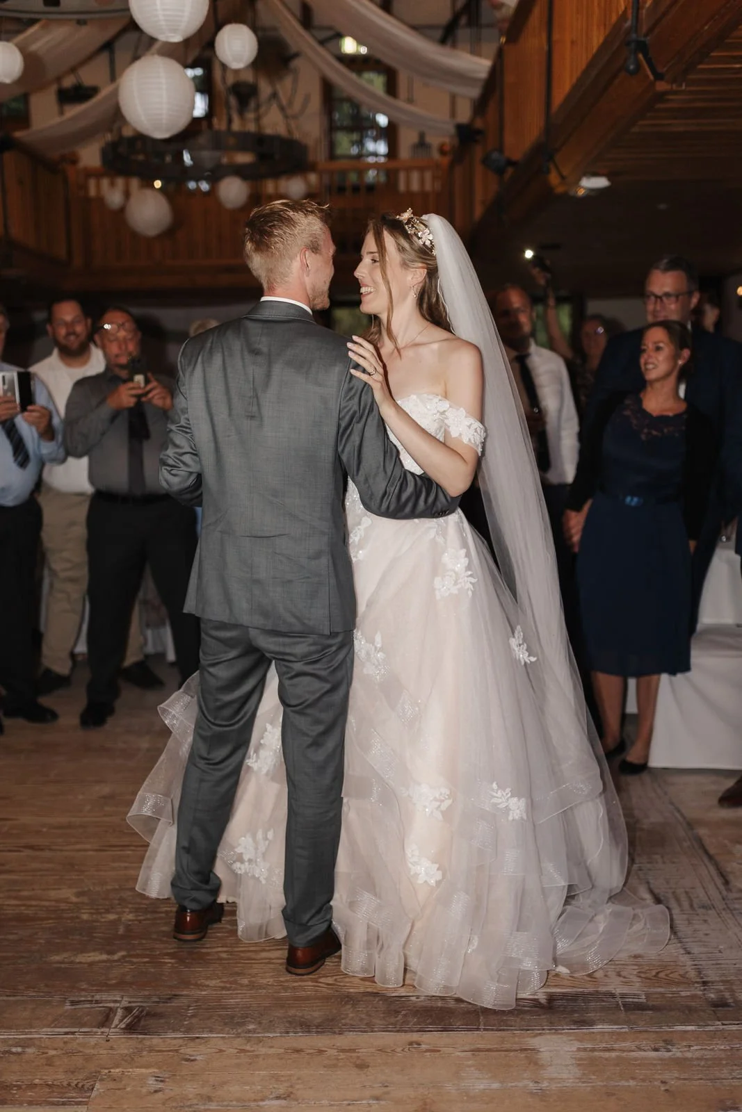 Brautpaar beim romantischen Hochzeitstanz, umgeben von ihren Gästen im Heide Hotel Reinstorf bei Lüneburg.