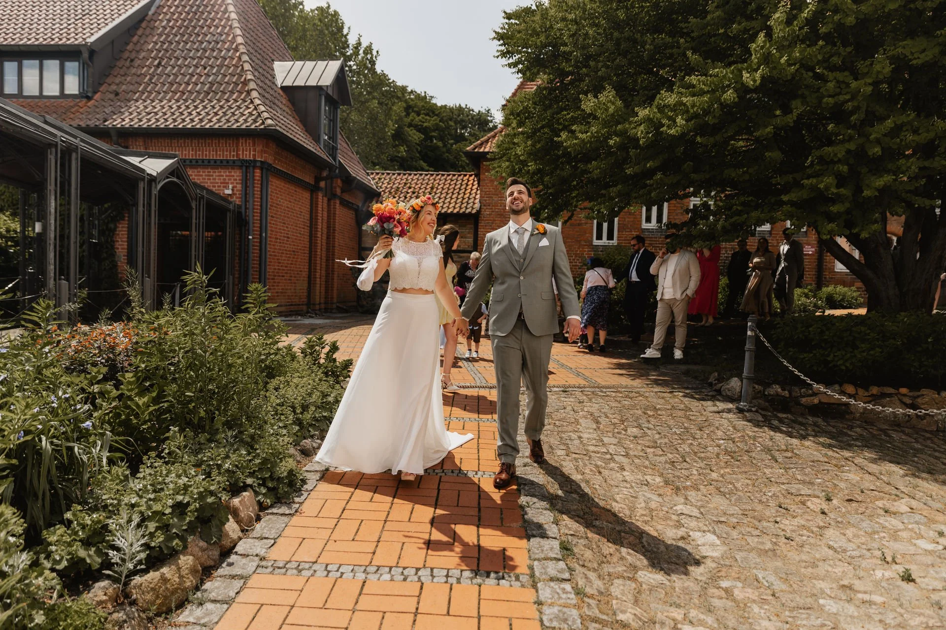Brautpaar verlässt Hand in Hand das Standesamt in Lüneburg nach der Trauung bei sonnigem Wetter