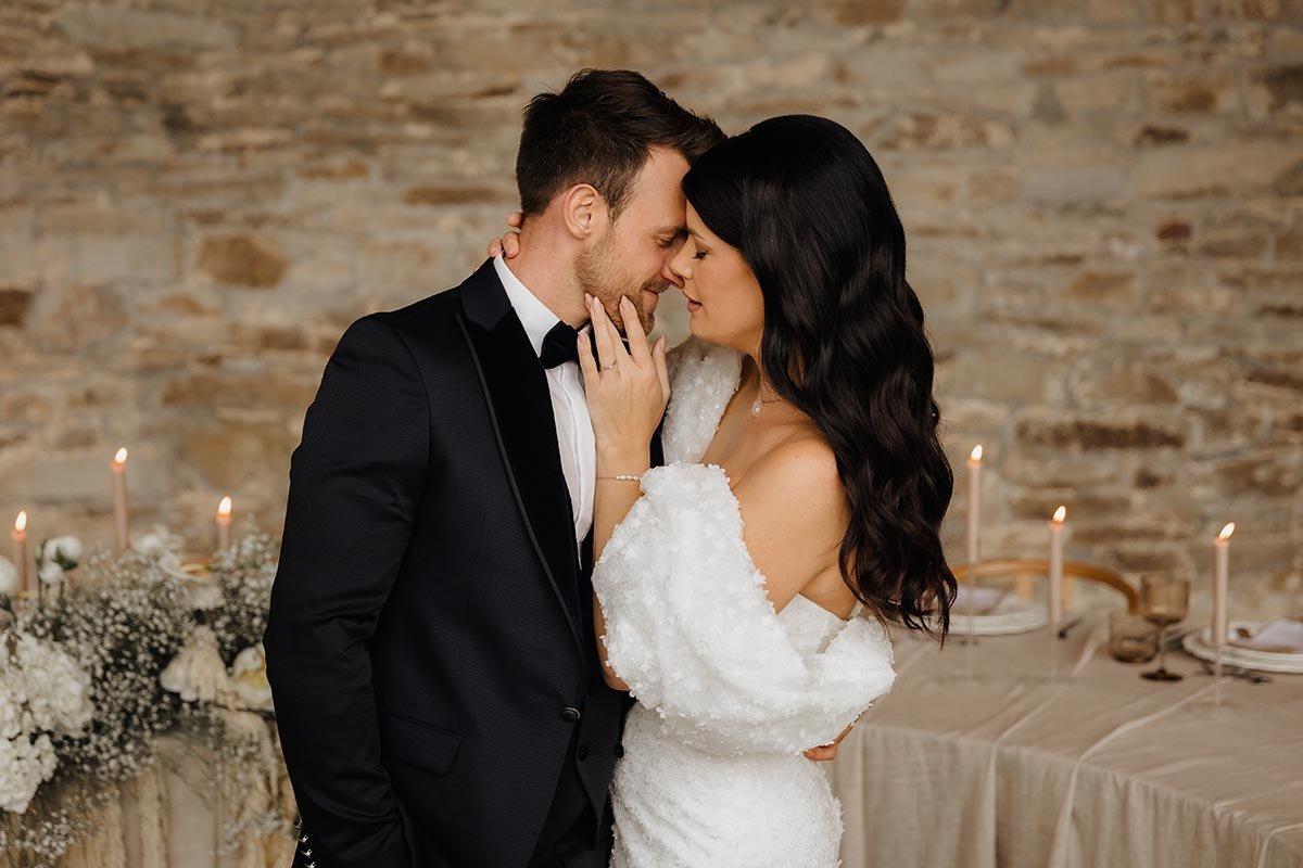Inniger Moment zwischen Braut und Bräutigam vor einer eleganten Hochzeitstafel – natürliche und emotionale Hochzeitsfotografie in Lüneburg