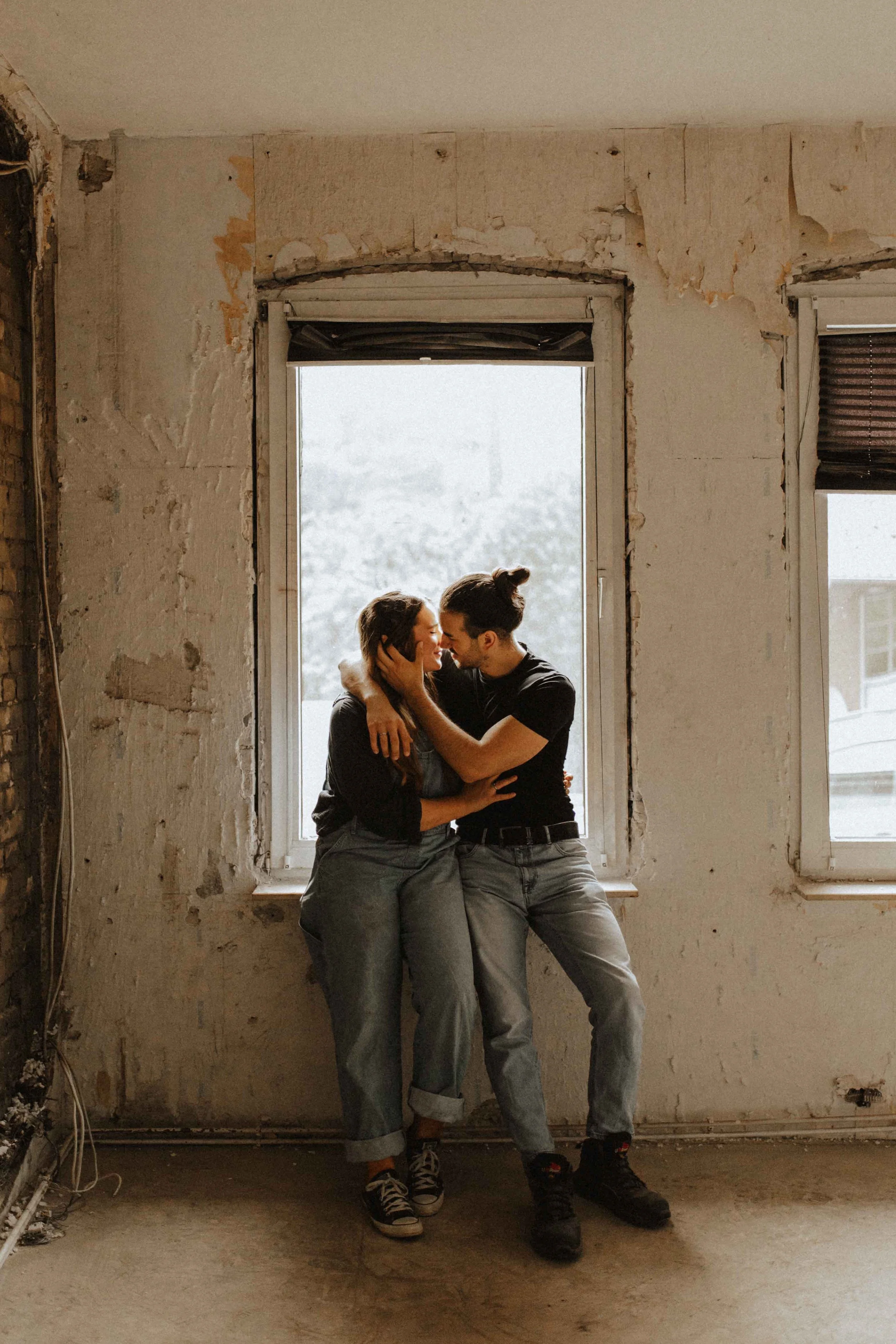 Paarshooting in Uelzen – Verliebtes Paar sitzt eng umschlungen auf einer Fensterbank in einem alten, charmanten Gebäude.